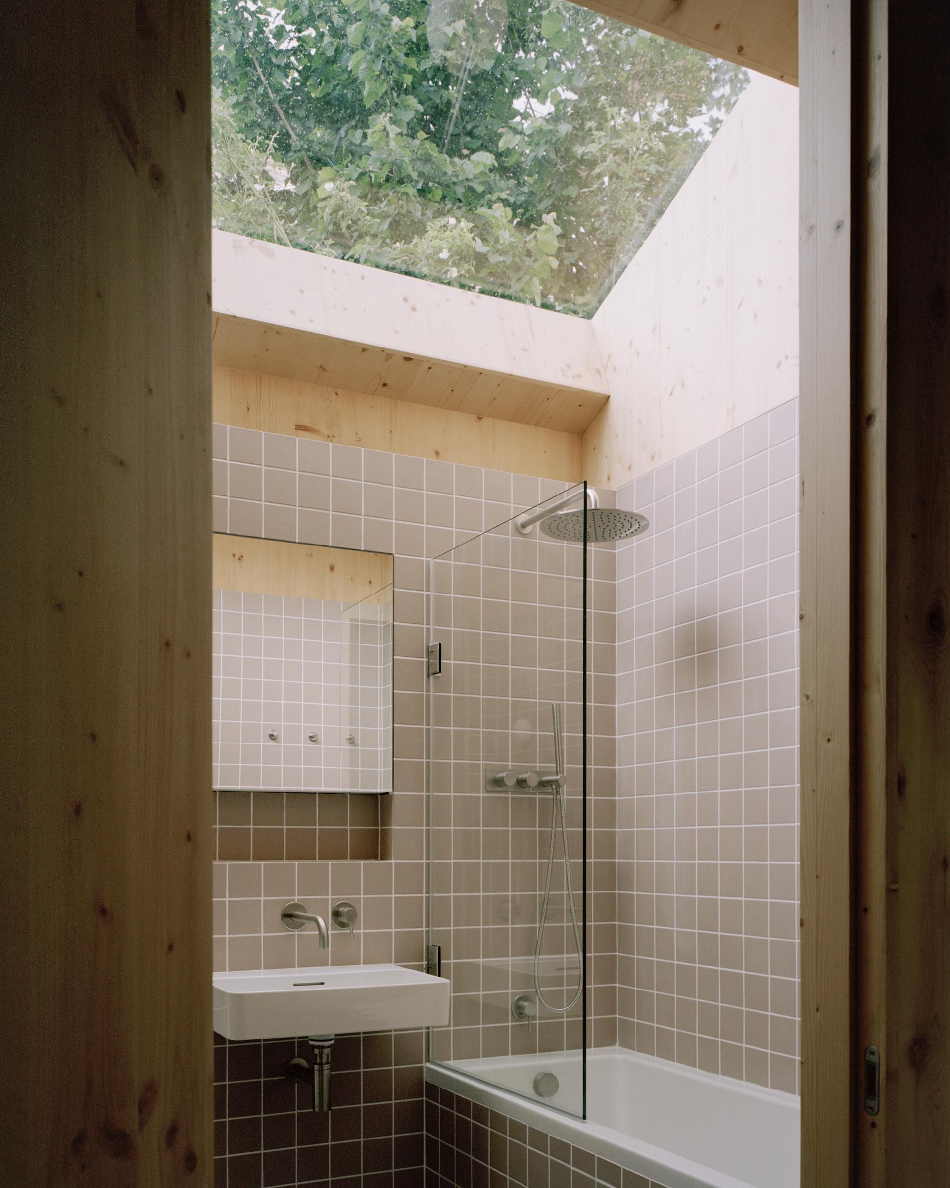 Modern bathroom featuring sustainable materials, skylights, and a minimalist design, highlighting the Tree Courtyard House's eco-friendly approach.