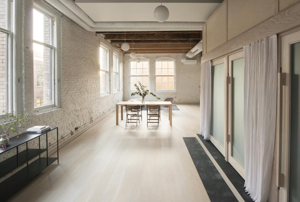 Spacious loft living area designed by Corey Kingston, featuring a dining table, natural light, and minimalist decor in Seattle.