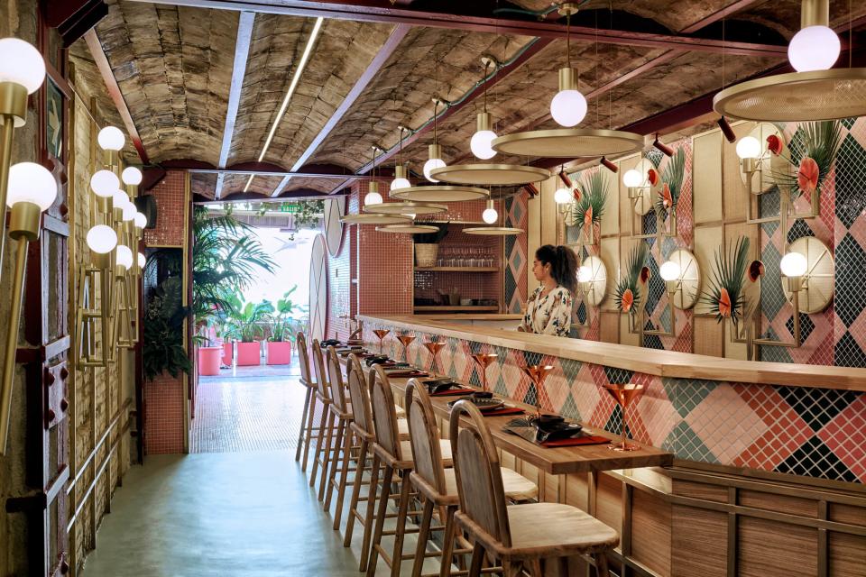 Tropical interior design of Kaikaya restaurant in Valencia, featuring vibrant decor and a stylish bar area.