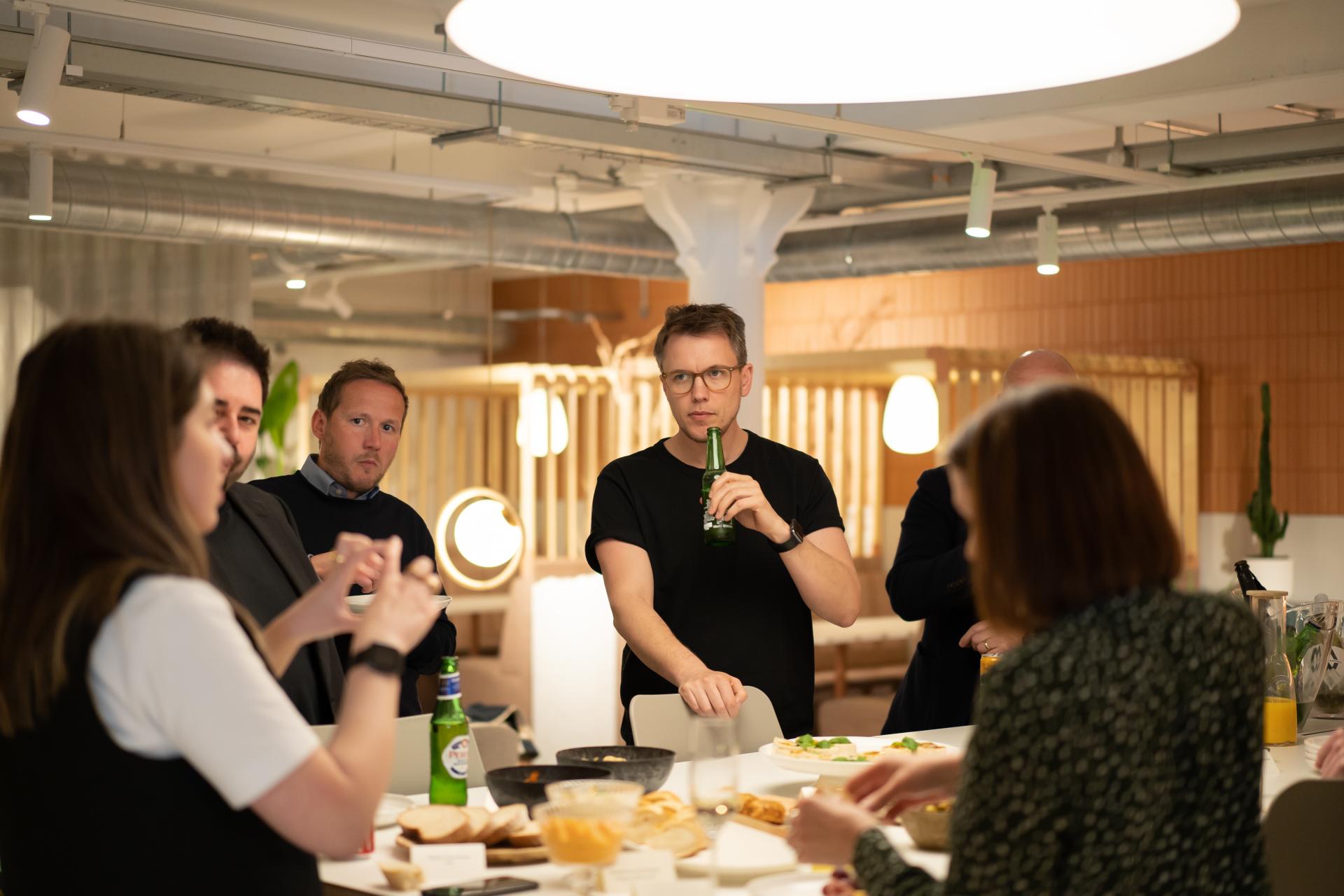 Colleagues networking and enjoying refreshments in a modern workplace setting during a technology seminar event.