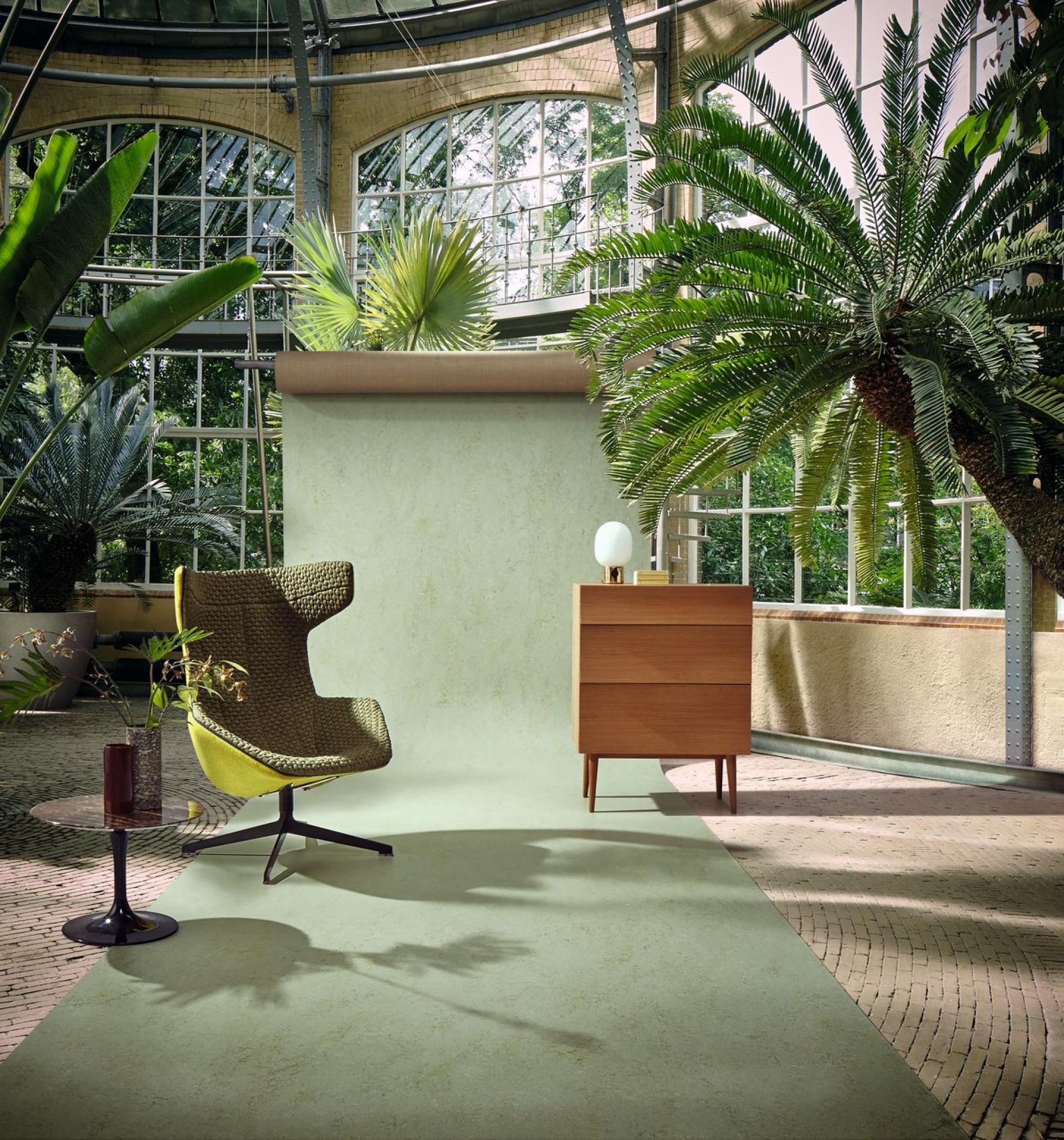 Marmoleum Marbled flooring in a bright, green indoor space featuring tropical plants and modern furniture elements.