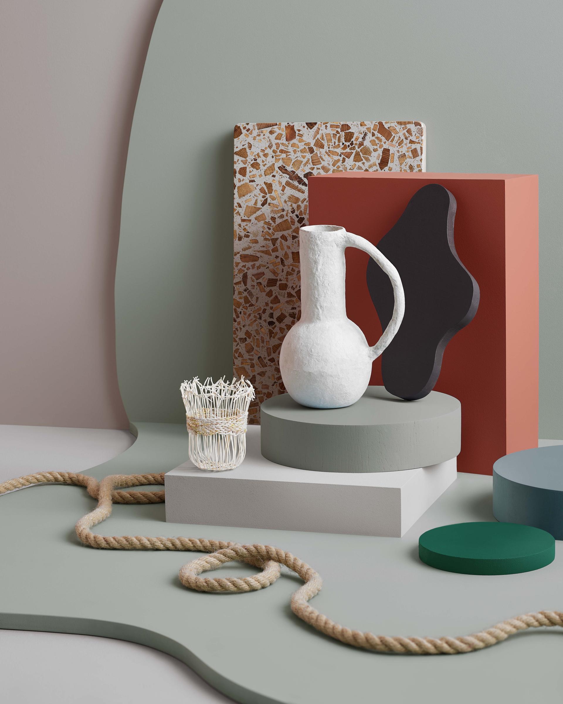 Stylish arrangement of decorative objects featuring a jug, container, and geometric shapes in modern colors, showcasing Crown Paints' 2024/25 trends.