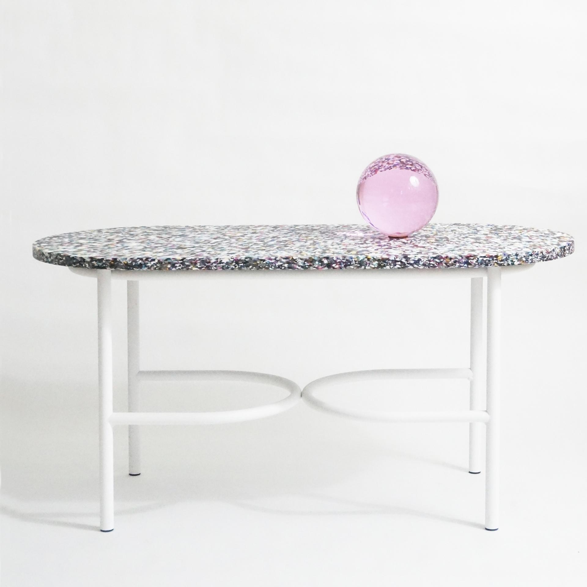 Colorful speckled tabletop with a pink glass orb, showcasing innovative design at Material Matters in London Design Festival 2023.