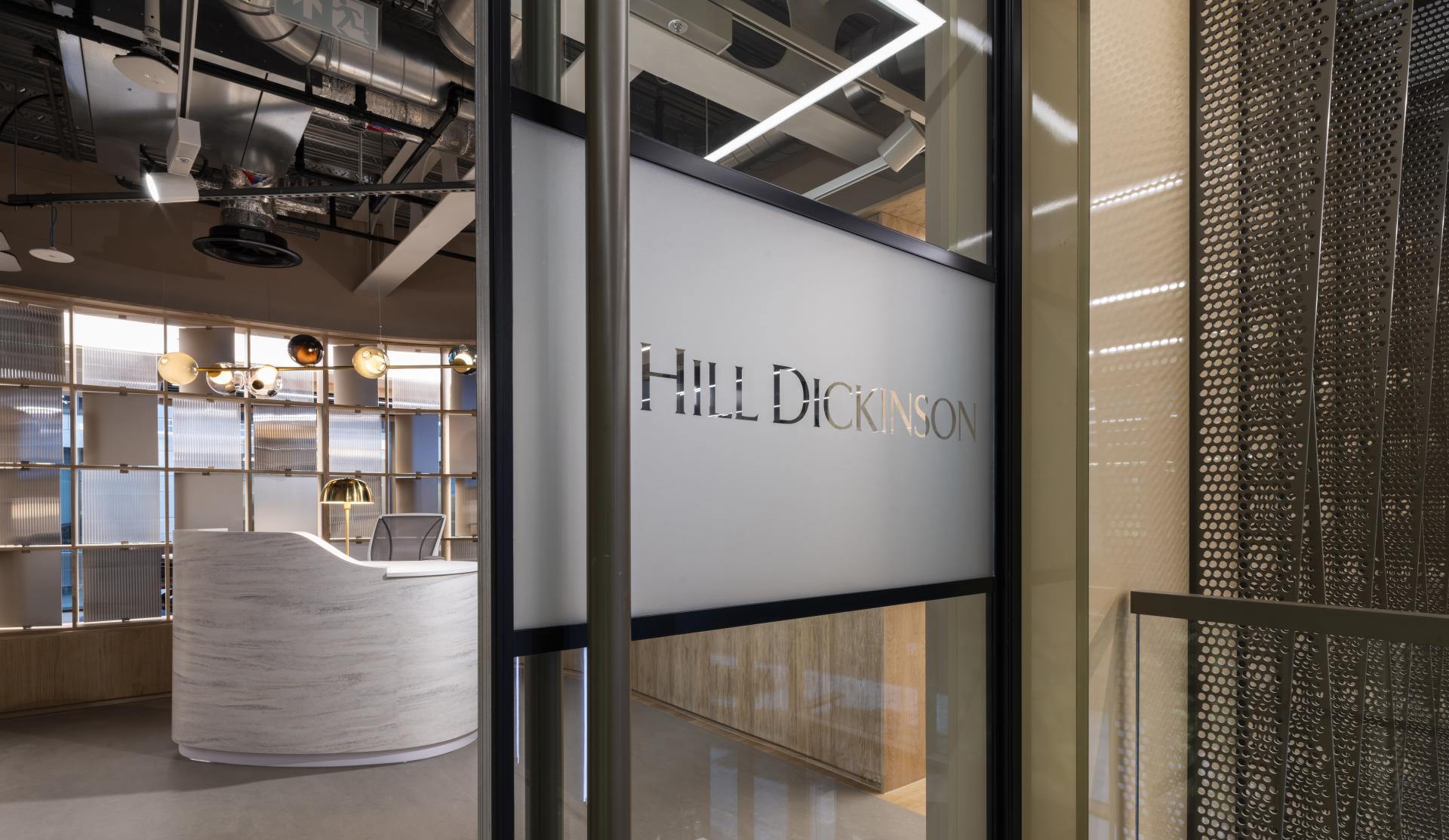 Contemporary office reception area featuring the etched glass sign for Hill Dickinson and stylish interior design elements.