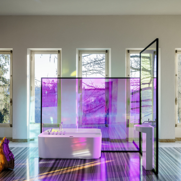 Elegant LAUFEN bathtub featured in a stylish bathroom with glass panels and large windows allowing natural light.