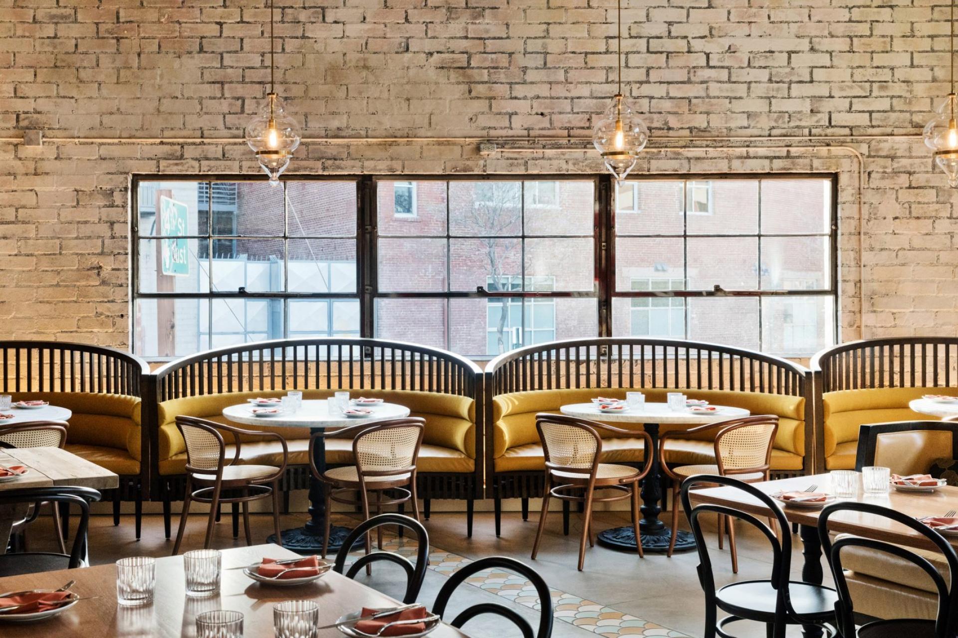Stylish restaurant interior featuring earthy tones, modern furnishings, and large windows, designed by Studio Unltd for Bavel in Los Angeles.