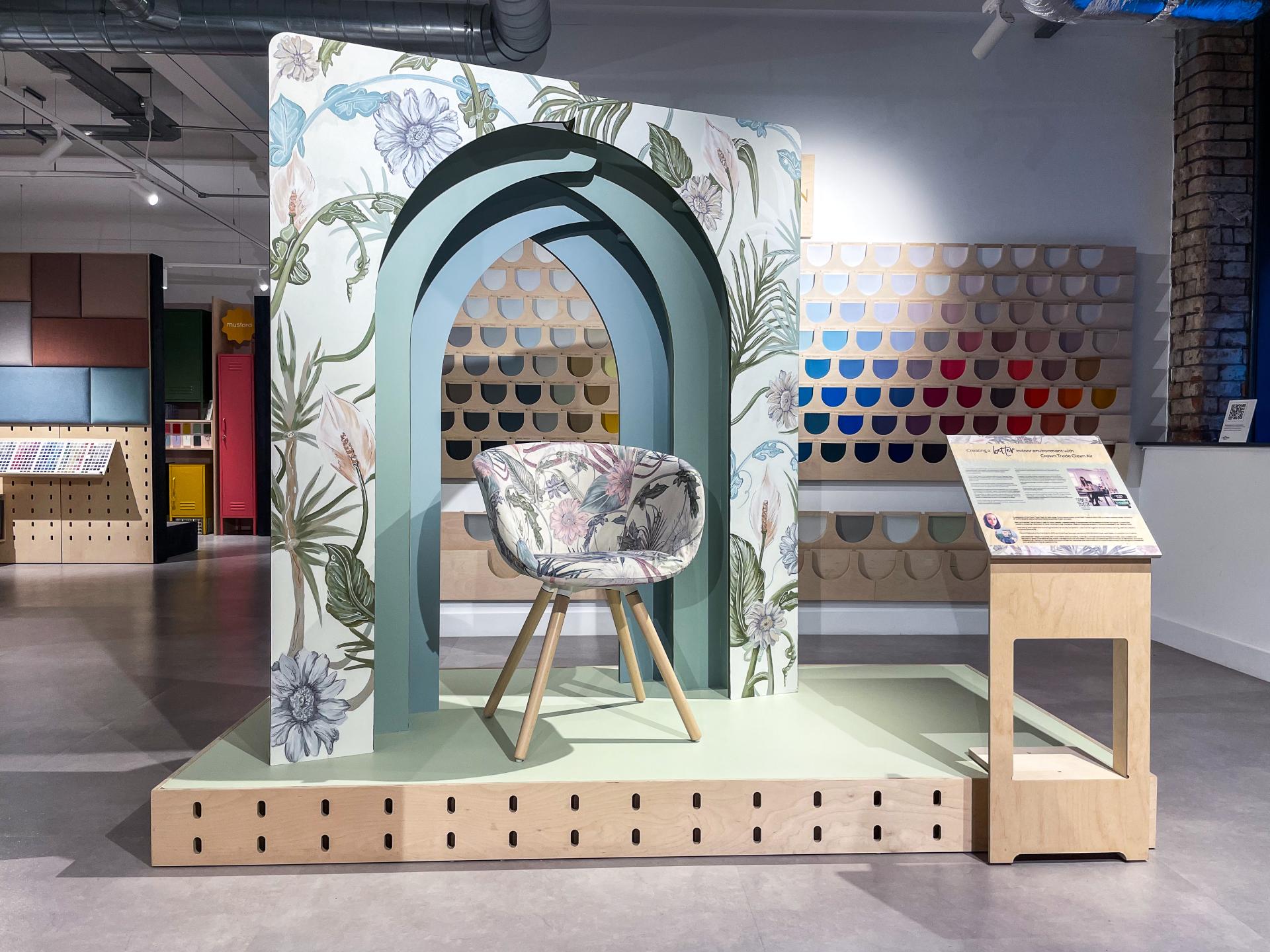 Design inspired by 'Poetry Of Purity' featuring a floral chair display and vibrant paint color samples.