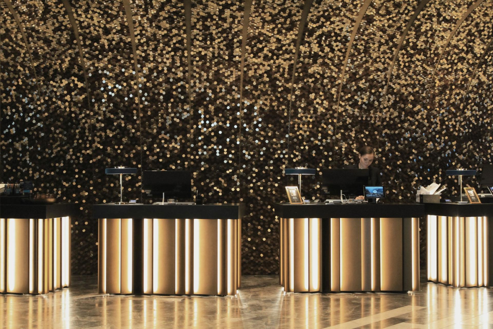 Modern reception area with shimmering gold accents and a designer's attention to materiality and form.
