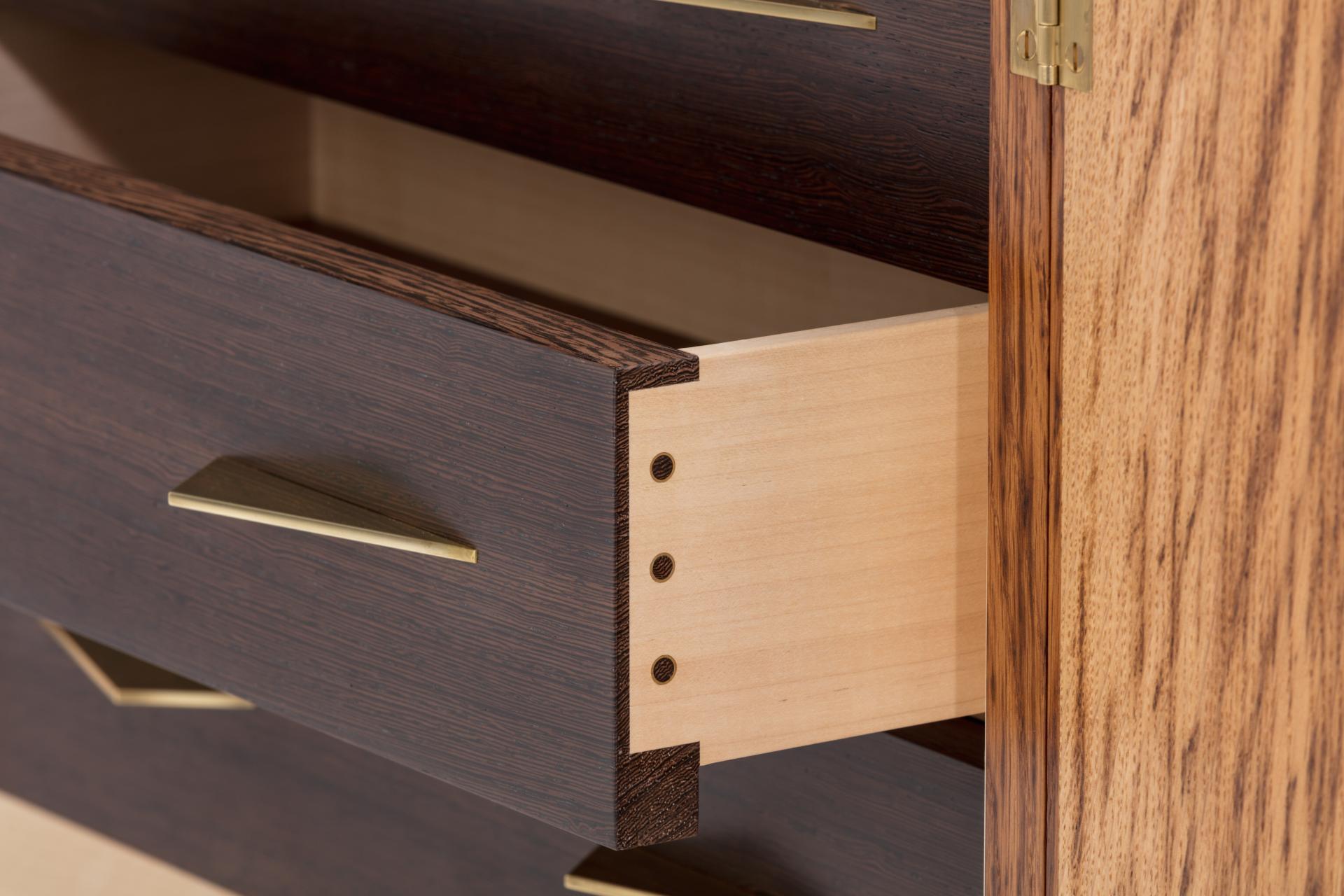 Contemporary wooden drawers with brass handles, showcasing intricate design by furniture maker Laurent Peacock for London Craft Week.
