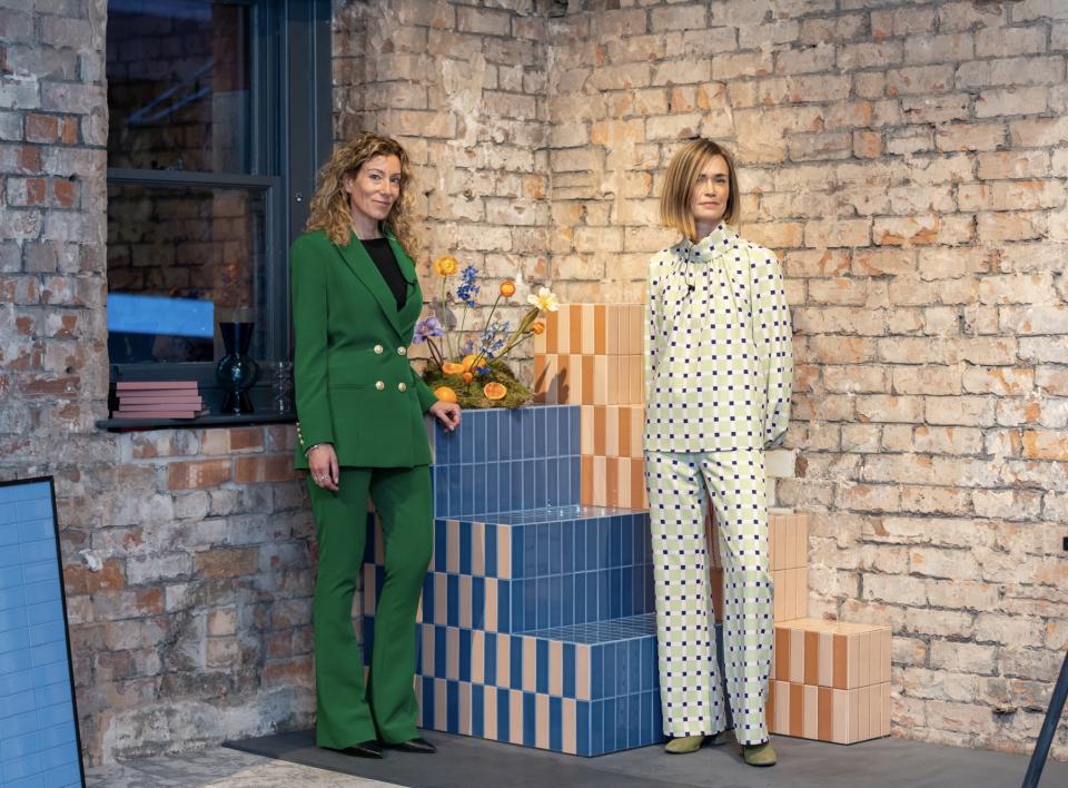 Tekla Severin and Ramona Macchi pose beside colorful tiles and floral arrangements, highlighting the Färgblock collection's playful design.