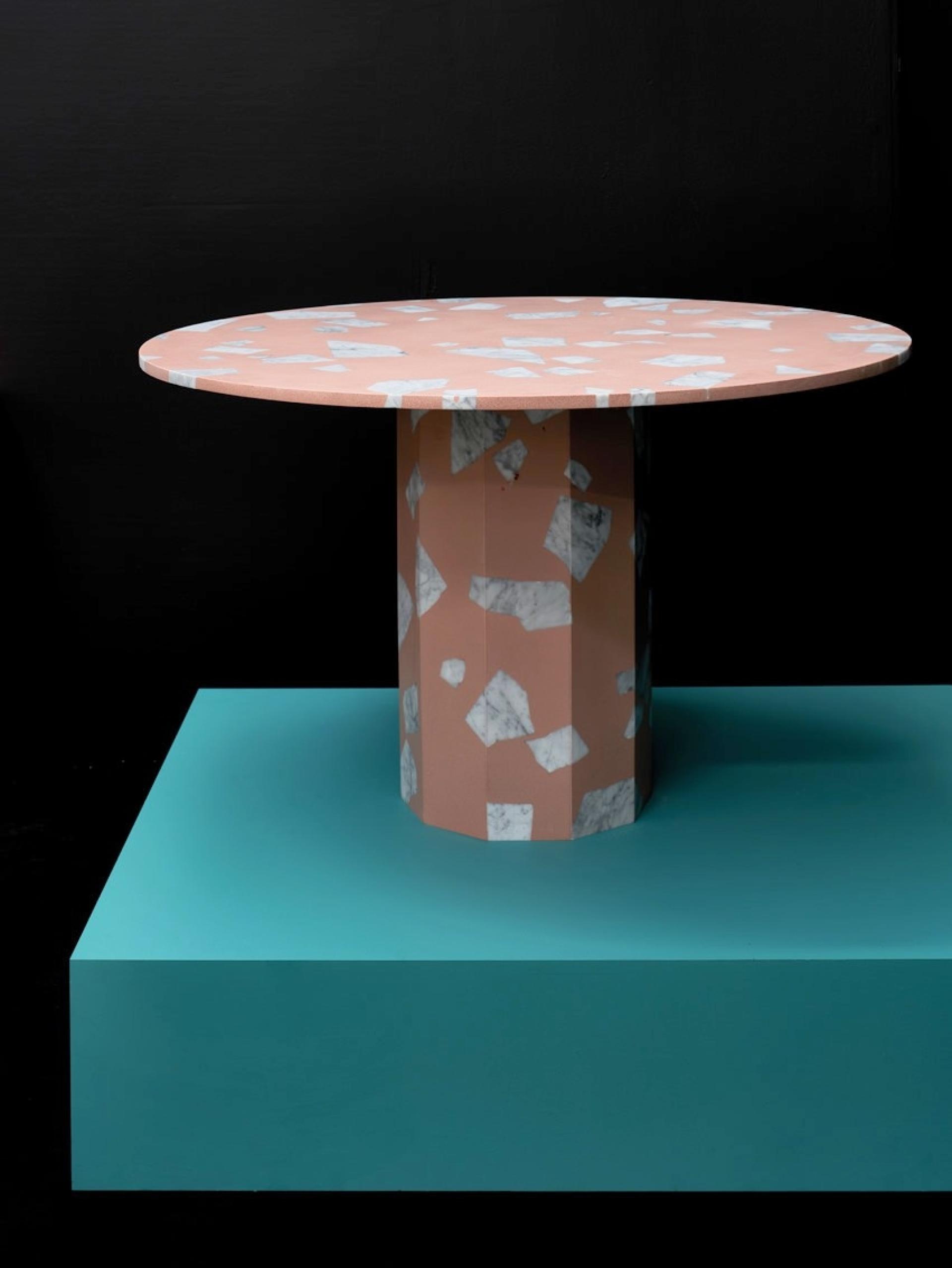 Stylish round table with a pink and marble top, resting on a turquoise base, featured in 2019 design trends review.