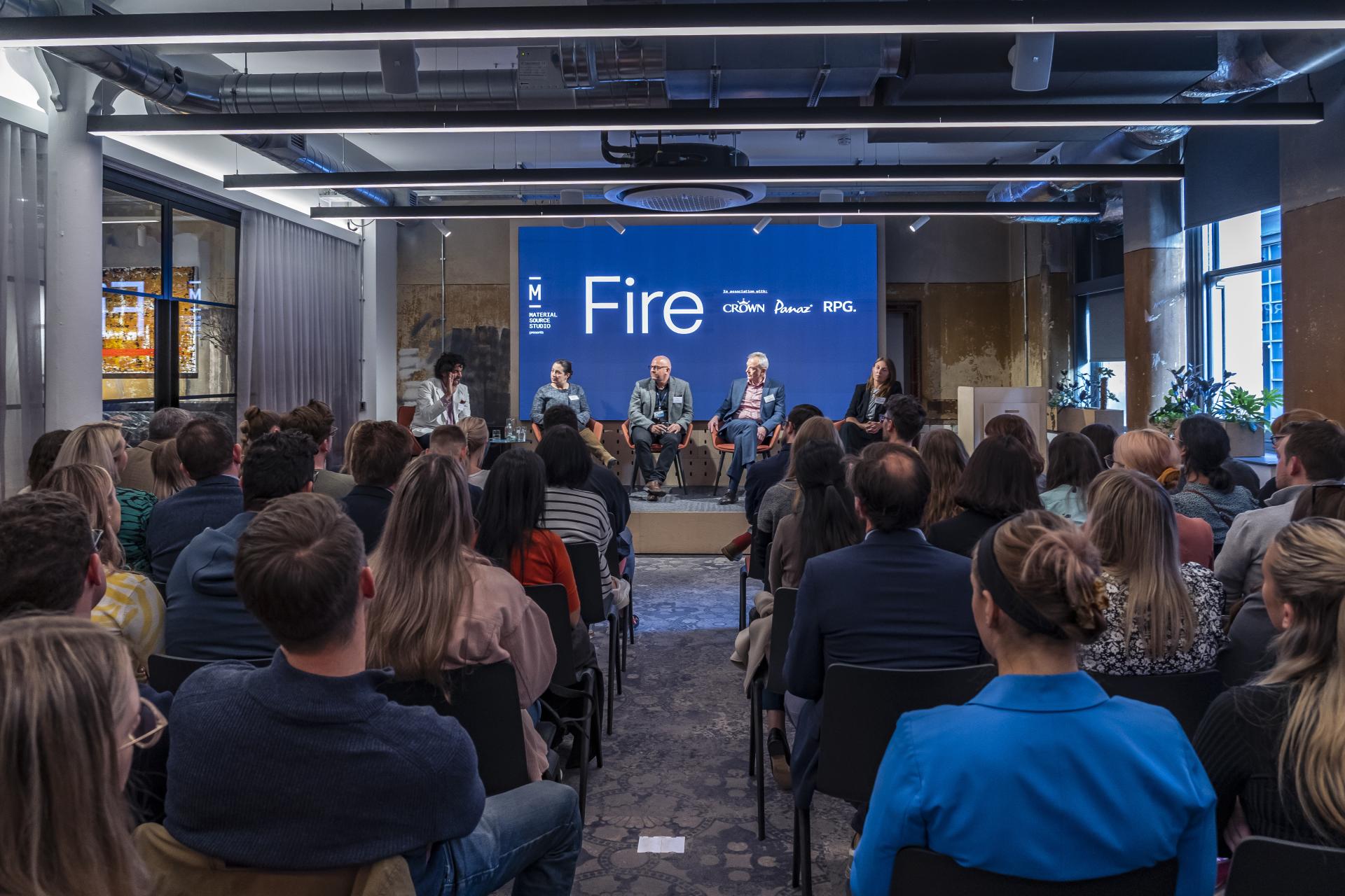 Panel discussion at the Material Source Studio seminar titled "Fire," featuring industry experts engaging with an audience.