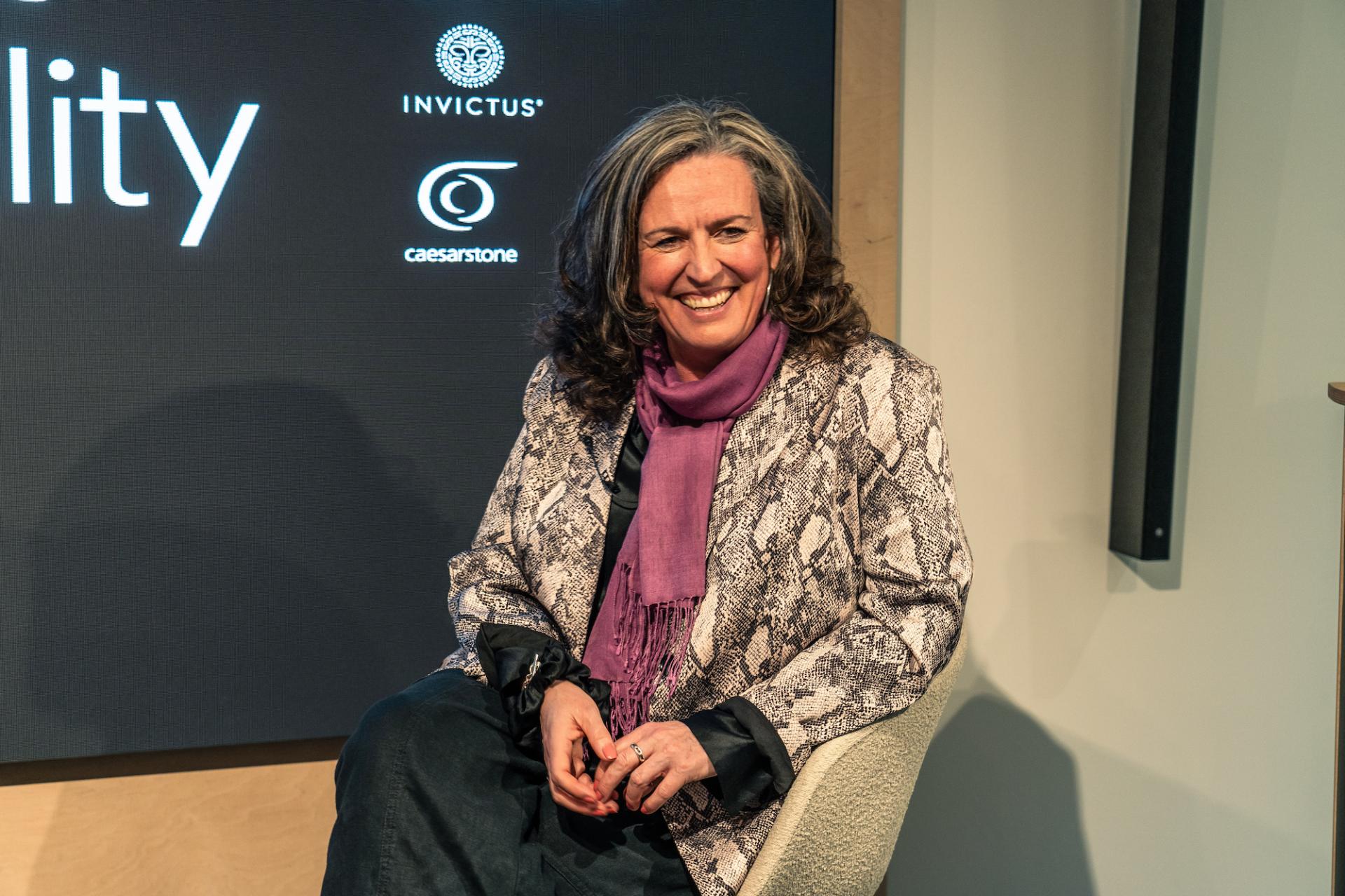 Speaker at Material Source Studio Glasgow event discussing the real cost of sustainability, seated in a modern chair.