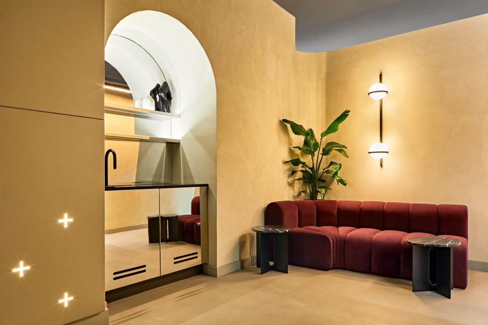 Modern reception area of Medika Clinic featuring plush red seating, sleek decor, and greenery for a comforting ambiance.