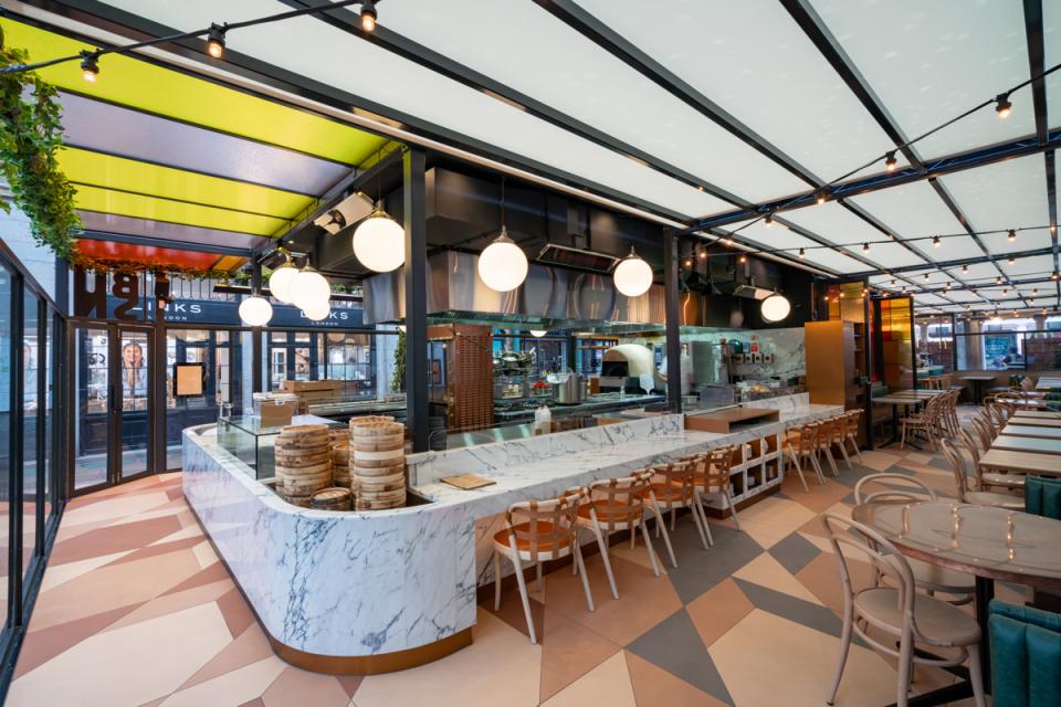 Vibrant interior design of Buns & Buns restaurant in Covent Garden featuring marble counters and stylish lighting.