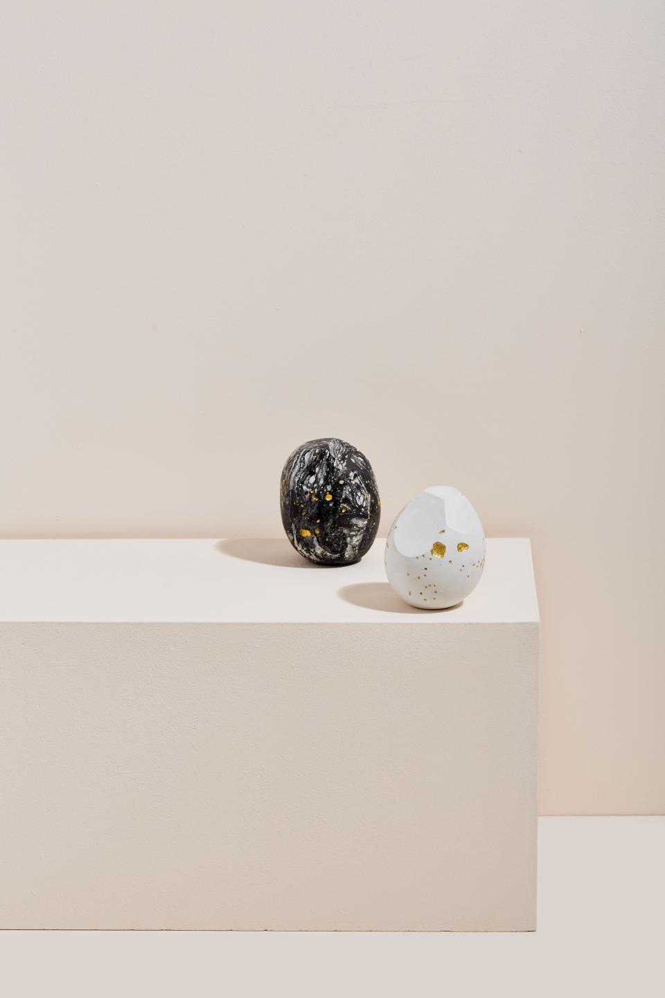 Abstract sculptures by Vic Wright, showcasing intricate material combinations with black and white finishes, on a minimalist pedestal.