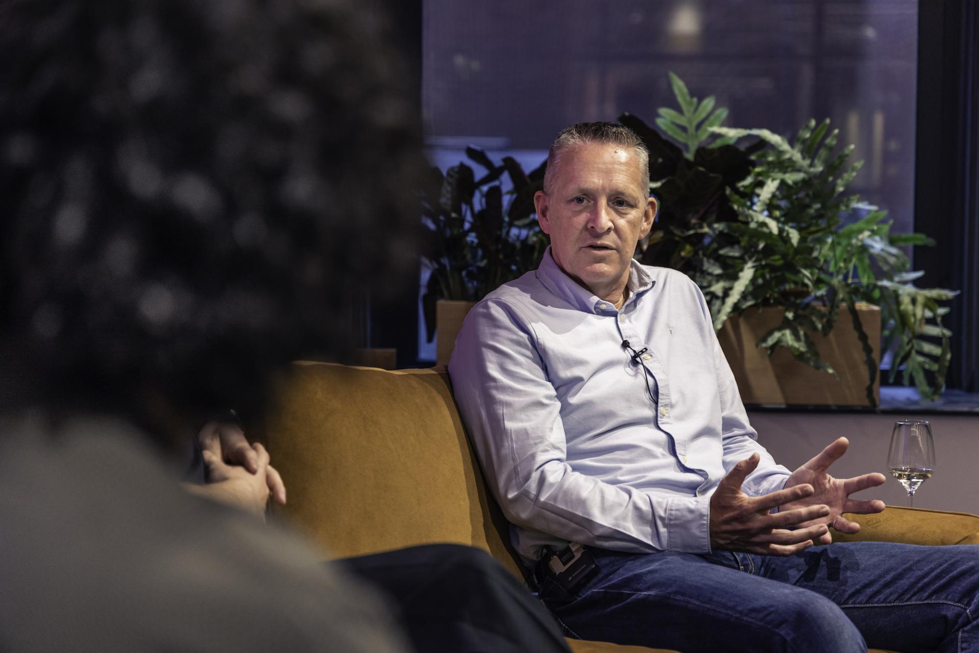 Discussion on technology's role in workplace reintegration, featuring a man speaking in a modern office setting with plants.