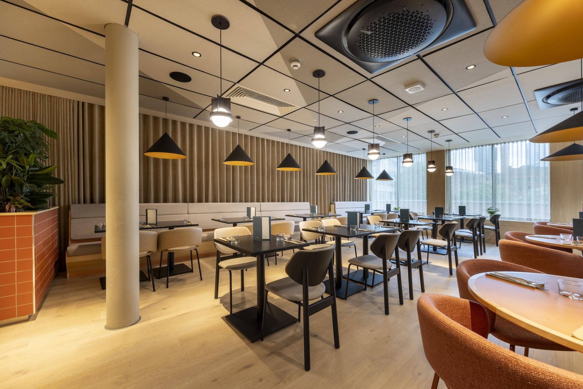 Stylish interior of a restaurant featuring modern furnishings, pendant lights, and an inviting atmosphere, designed by Up North Architects.