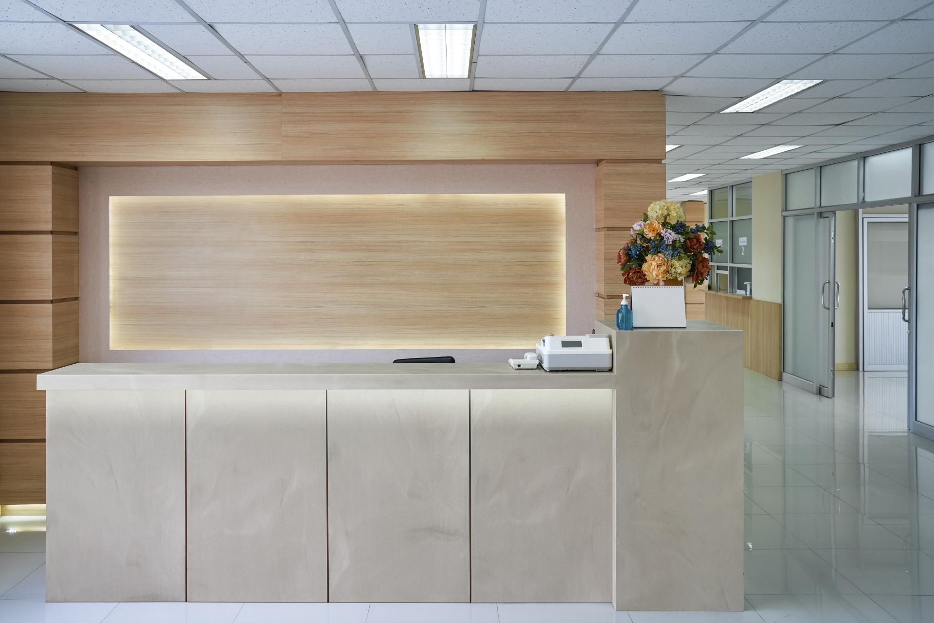 Modern reception area featuring new Corian color range with soft hues and stylish wooden accents.