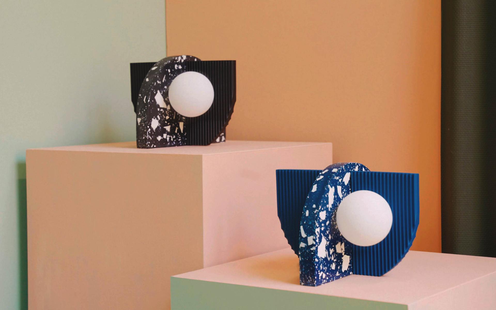 Abstract ceramic sculptures with geometric shapes and contrasting colors displayed on pastel pedestals, highlighting contemporary design.