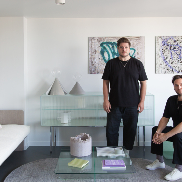 Designers showcasing contemporary commercial interior decor with stylish furnishings and textured wall art by Newmor.
