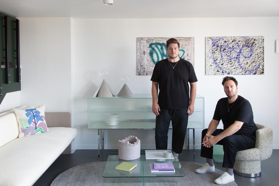 Designers showcasing contemporary commercial interior decor with stylish furnishings and textured wall art by Newmor.