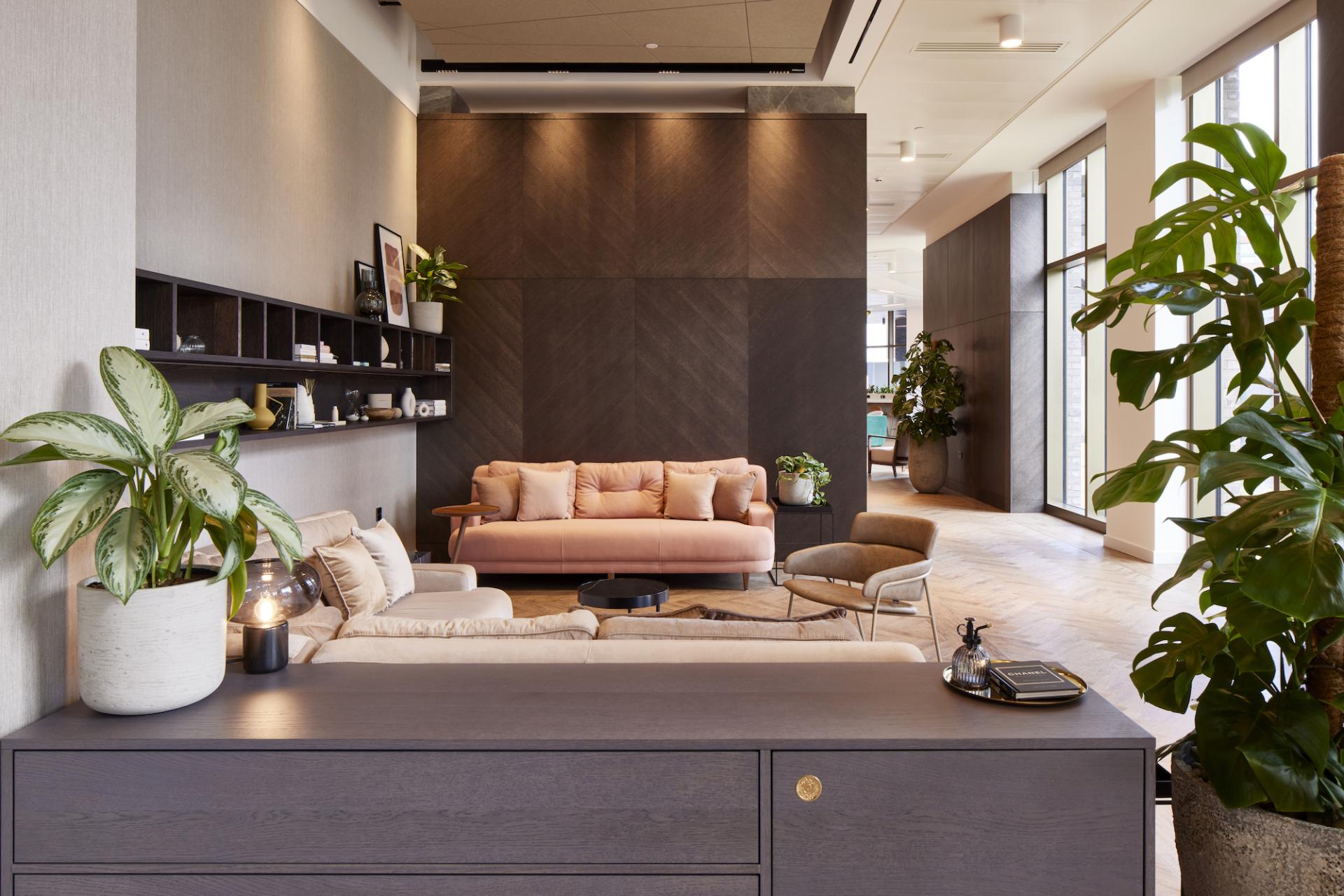 Modern residential amenity space designed by SpaceInvader, featuring stylish furniture, plants, and natural light.