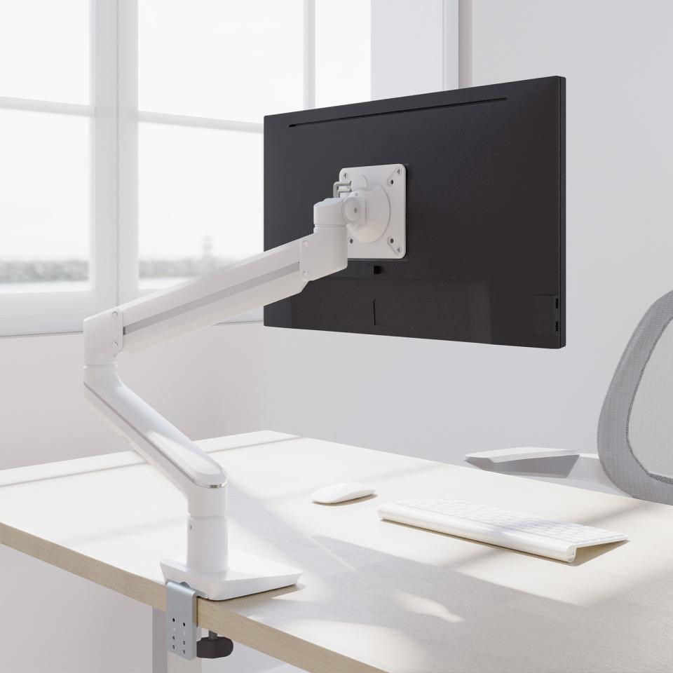 Stylish white Fellowes Tallo™ monitor arm supporting a black screen in a modern office workspace with natural light.
