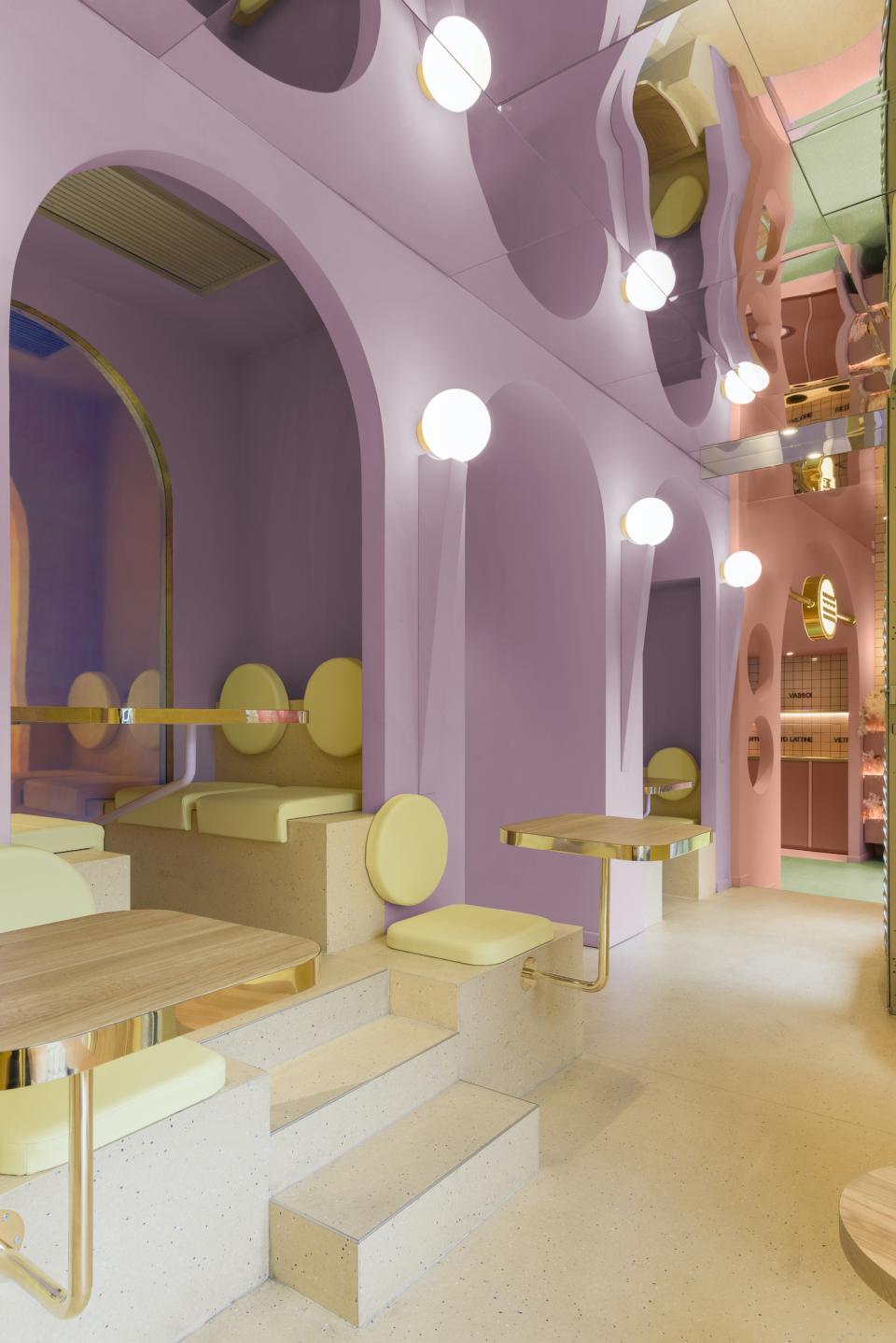 Colorful interior of Masquespacio's Bun in Milan, featuring pastel arches, modern seating, and unique lighting accents.