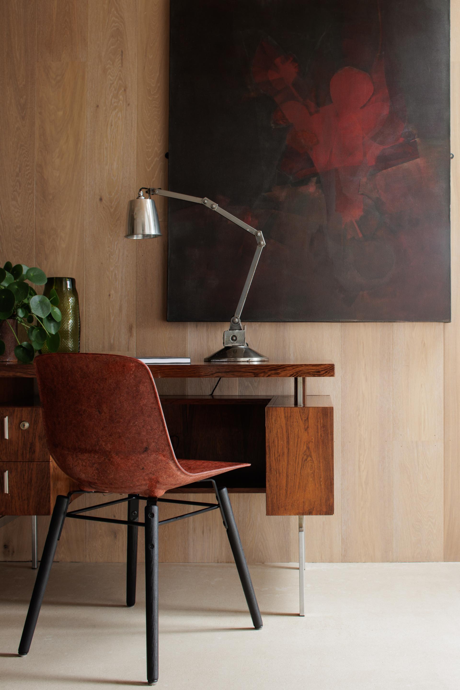 Stylish workspace featuring a Solidwool chair, sleek wooden desk, and modern lamp against a textured wall.