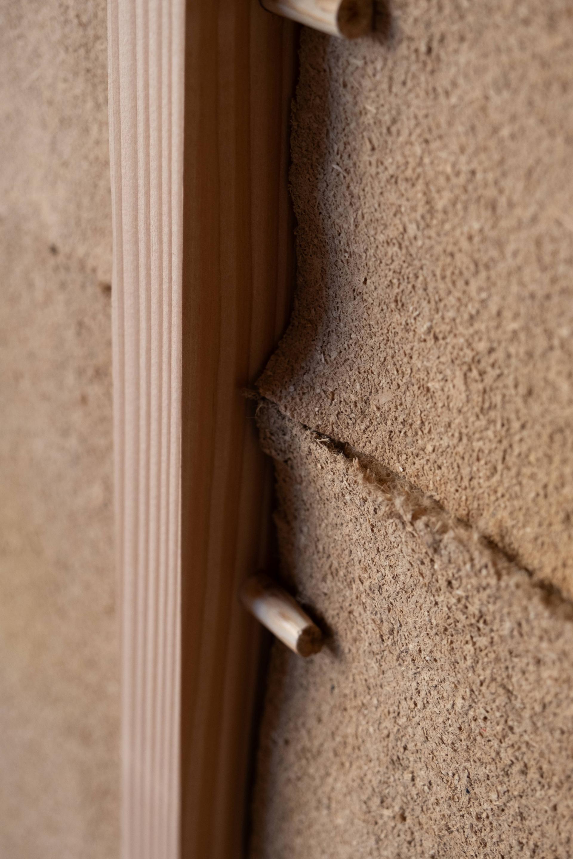 Close-up of wood elements integrated with textured natural materials, showcasing innovative architectural details in SMULD design.