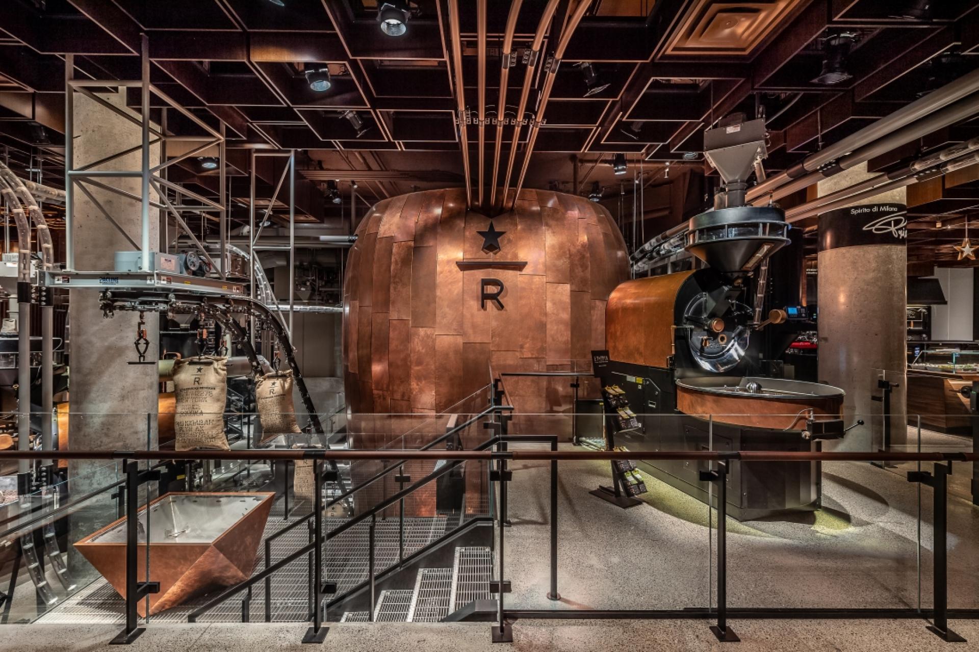 Interior of a coffee roasting facility featuring large copper machinery and bags of coffee, highlighting coffee culture in 2019.