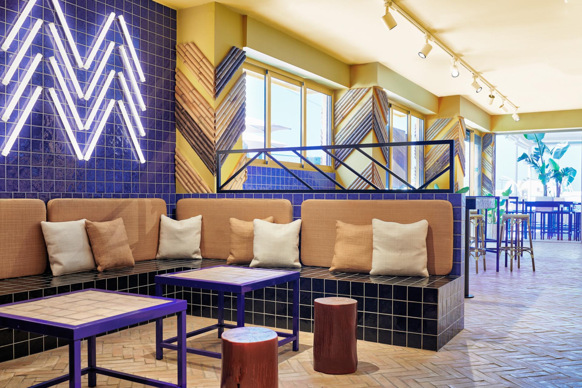 Stylish interior of Bar TORÖ in Ibiza, featuring Mediterranean-inspired materials, colorful tiles, and unique seating arrangements.