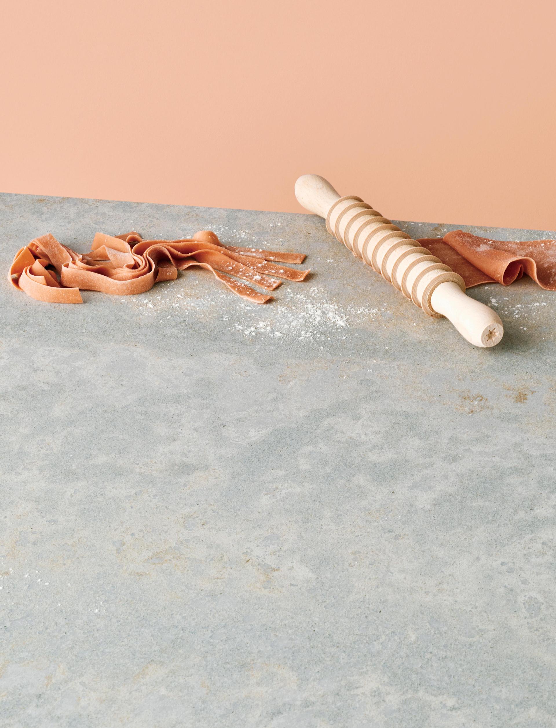 Rolling pin and fresh pasta on a Caesarstone 4043 Primordia countertop, showcasing its organic and versatile design.
