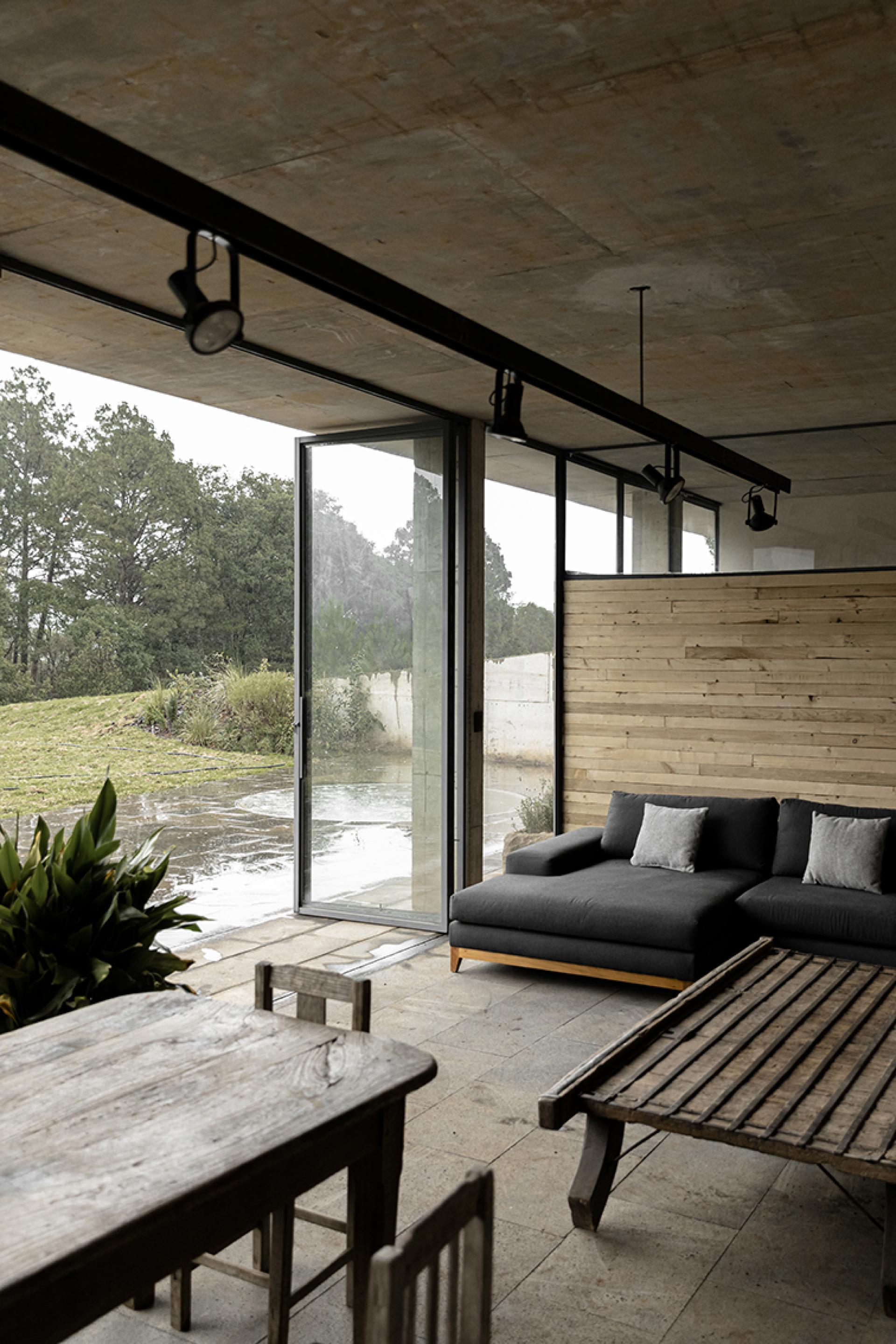 Modern interior of Avocado House showcasing minimalist design, large windows, and views of the lush Mexican forest.