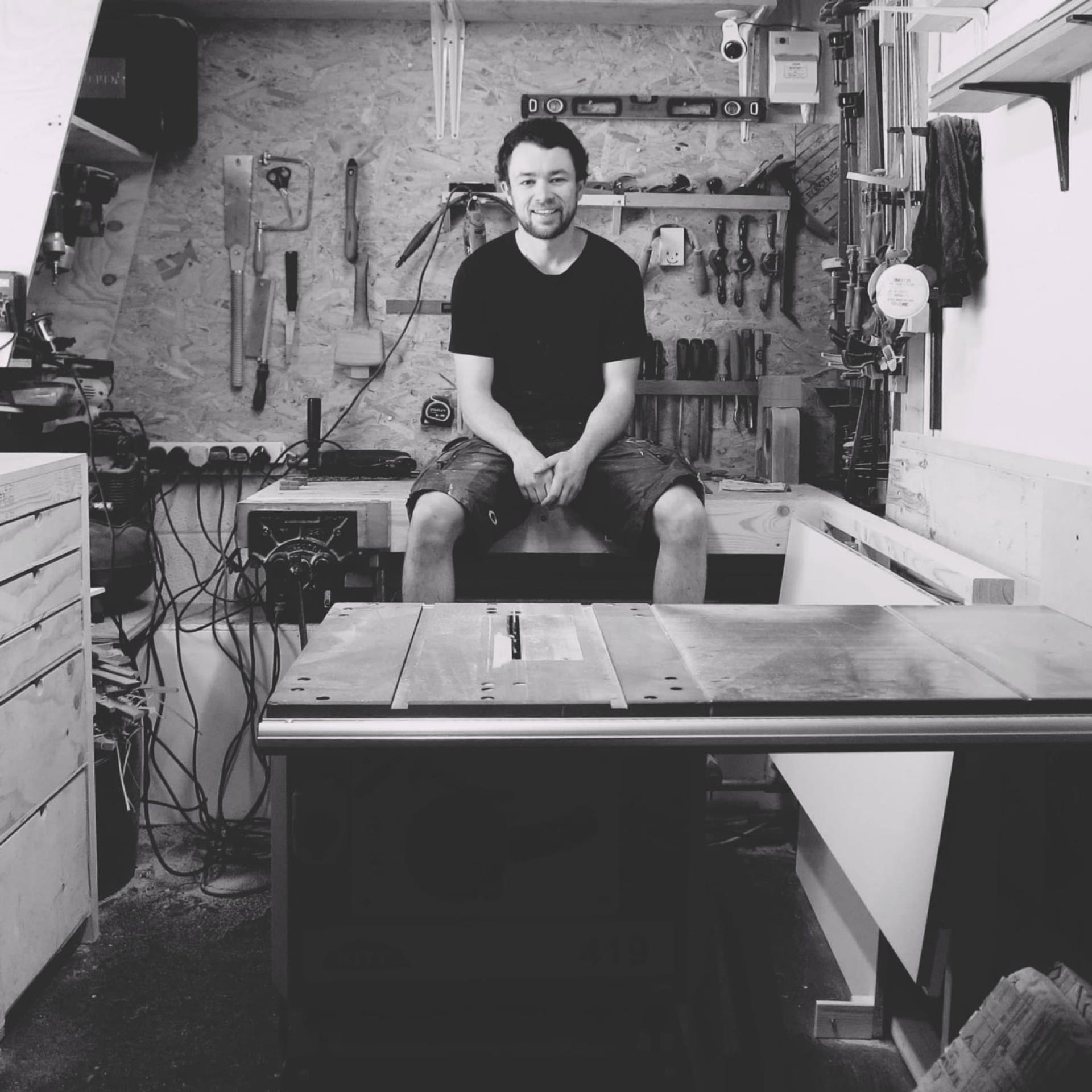 Craftsman sitting in a workshop surrounded by tools, showcasing the vibrant creative community in Bristol.