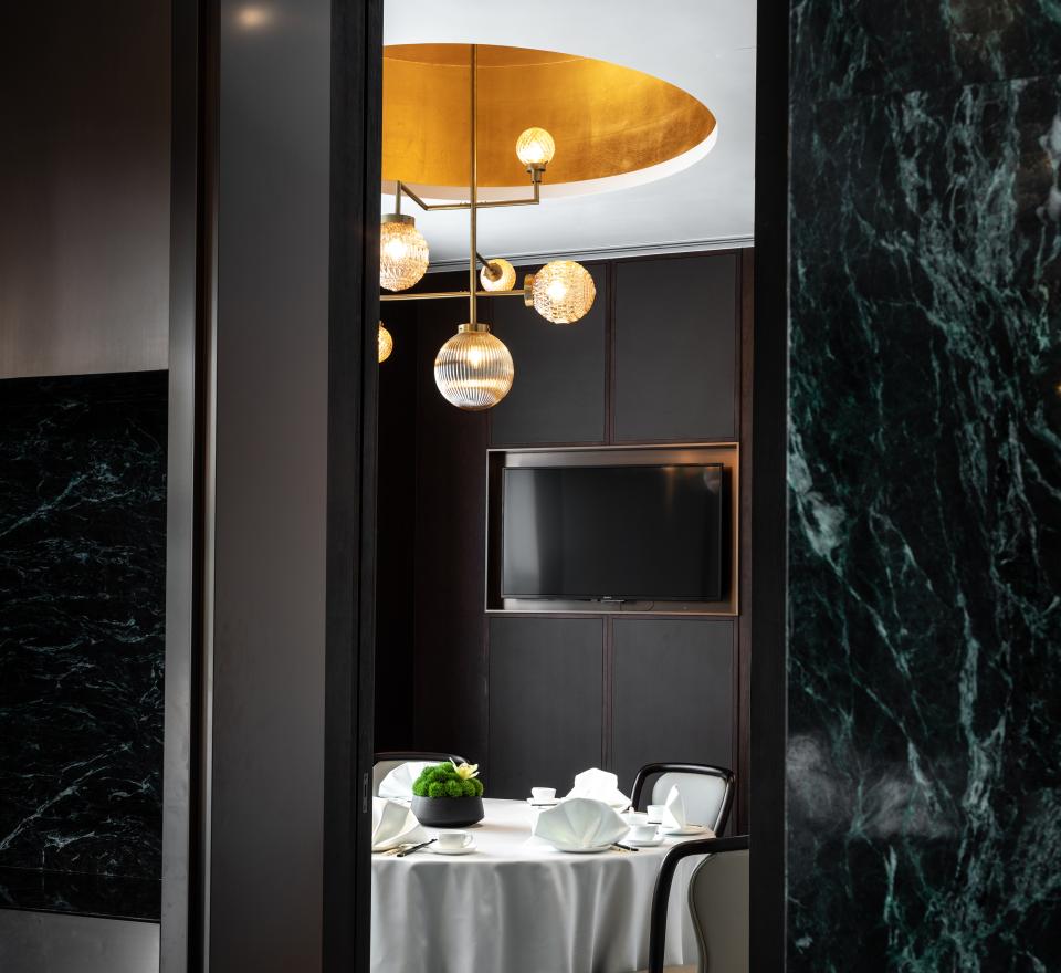 Sleek interior design of the Canton Room featuring a round dining table, elegant lighting, and modern decor in Wan Chai.