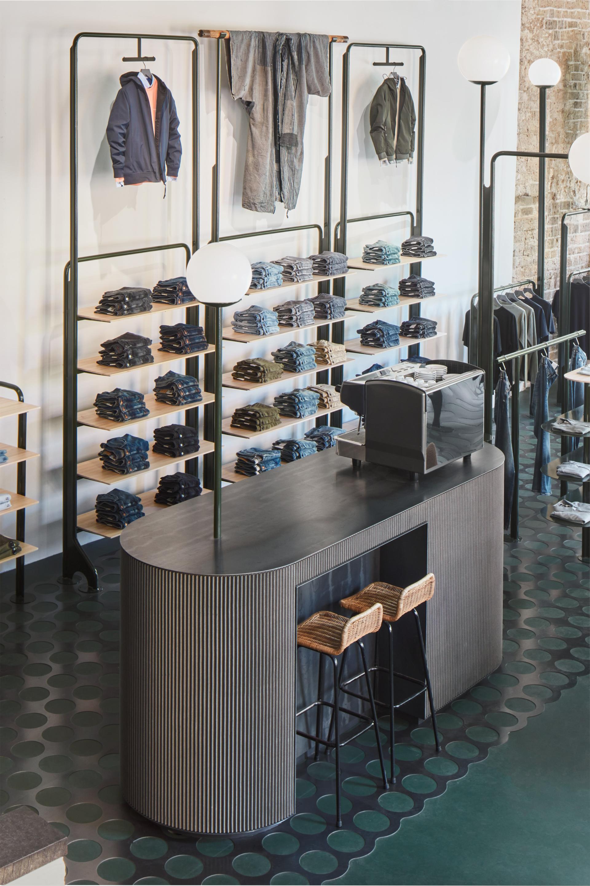 Modern COEF clothing shop interior featuring denim displays, stylish attire, and an inviting checkout counter in Utrecht.