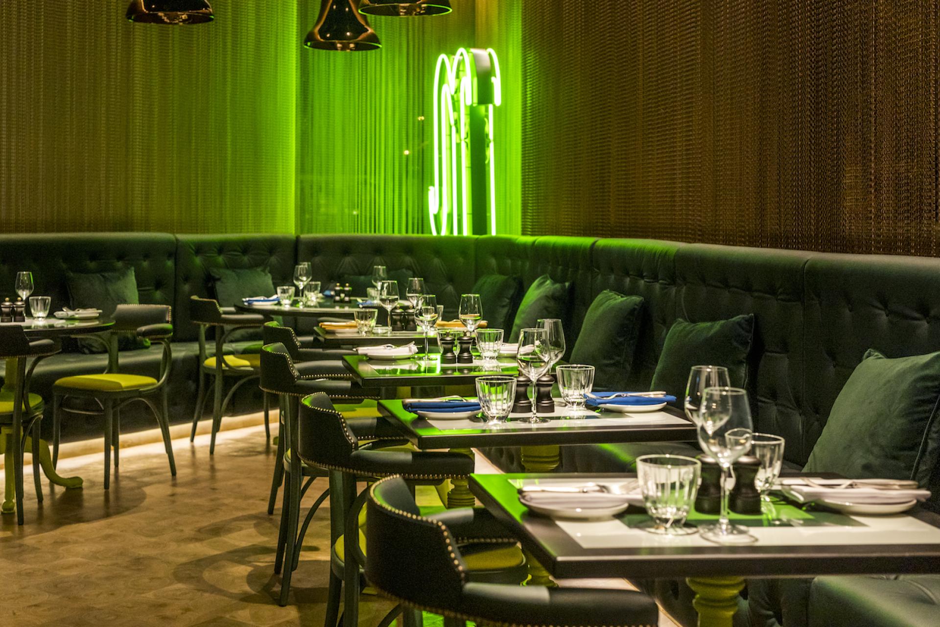 Stylish dining area featuring green accents and modern furniture at the nhow London hotel.