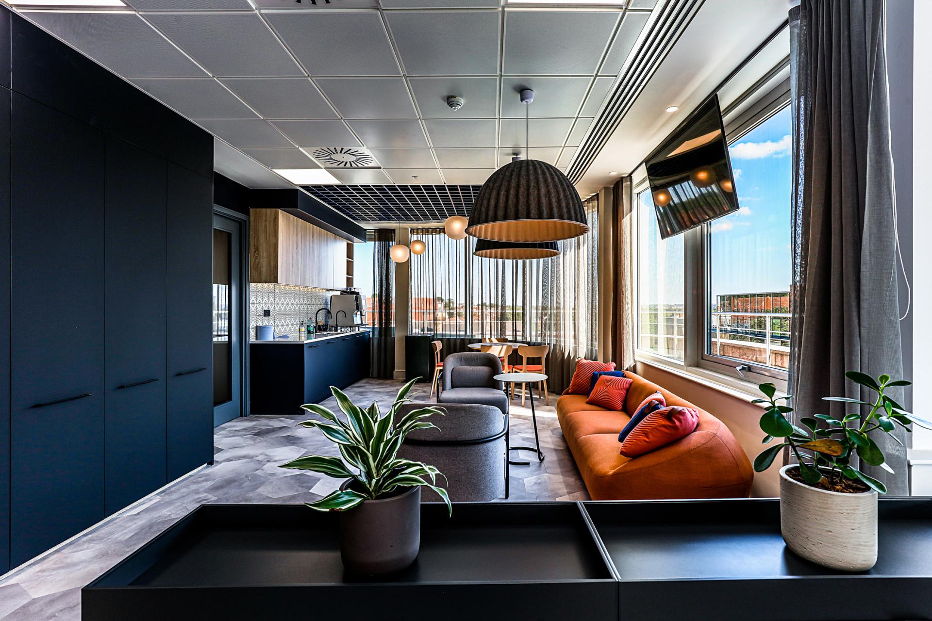 Modern office space featuring stylish furniture, large windows, and kitchen amenities at Domestic & General's Wimbledon headquarters.