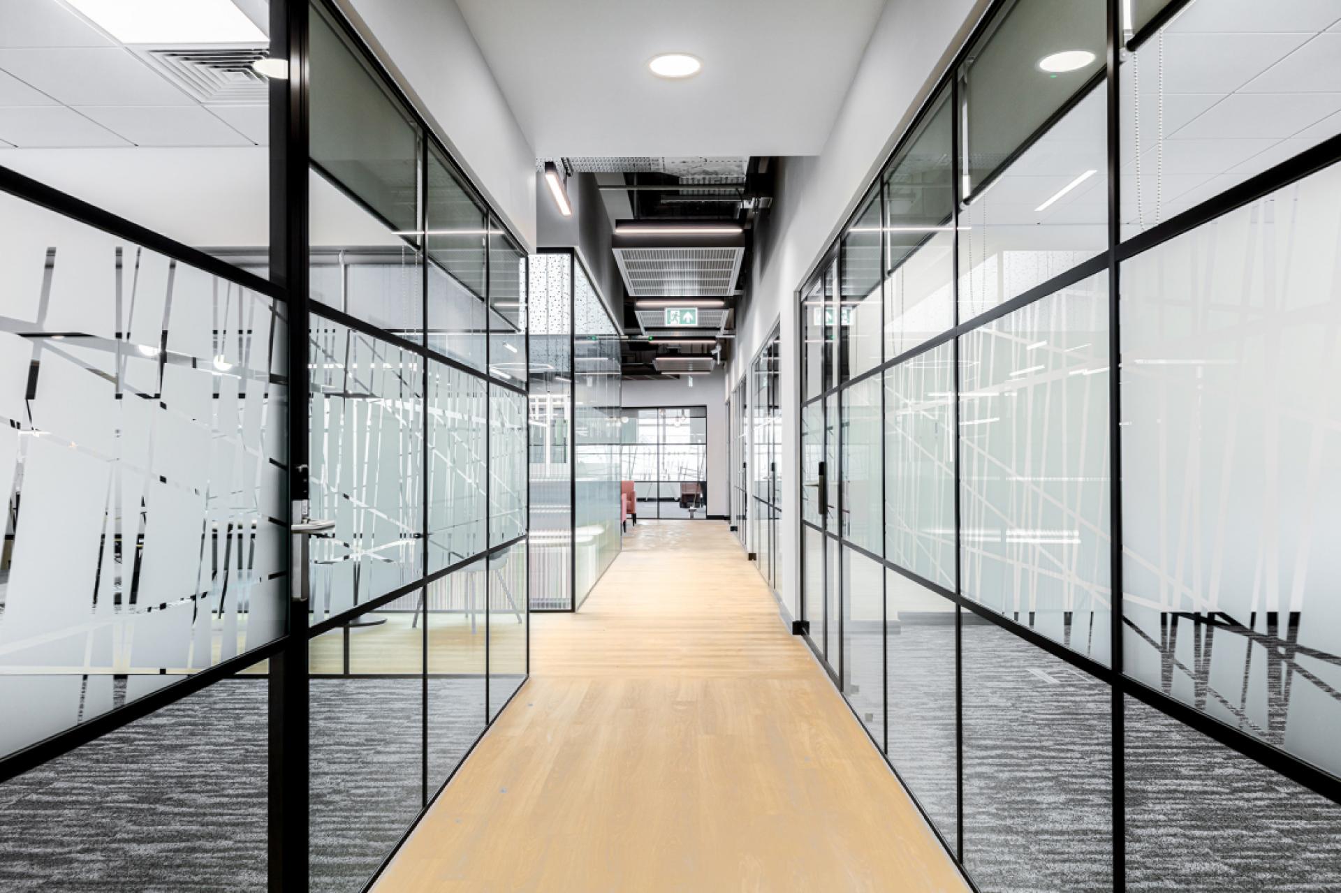 Modern office corridor featuring glass panel walls, showcasing the sleek design of Material Source Studio in Glasgow.