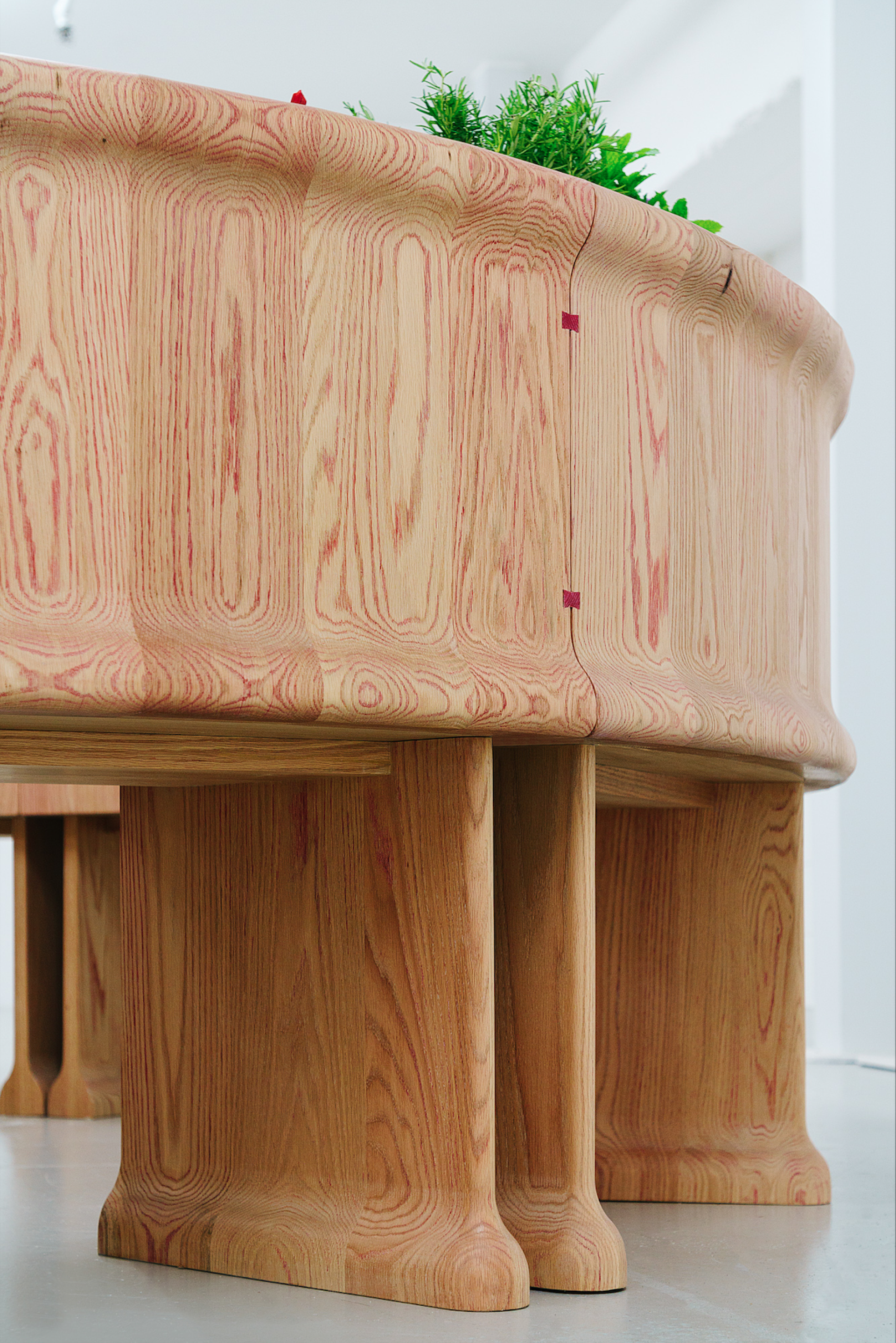 A close-up view of a unique red oak bar designed by Chan + Eayrs and Sebastian Cox during Milan Design Week.