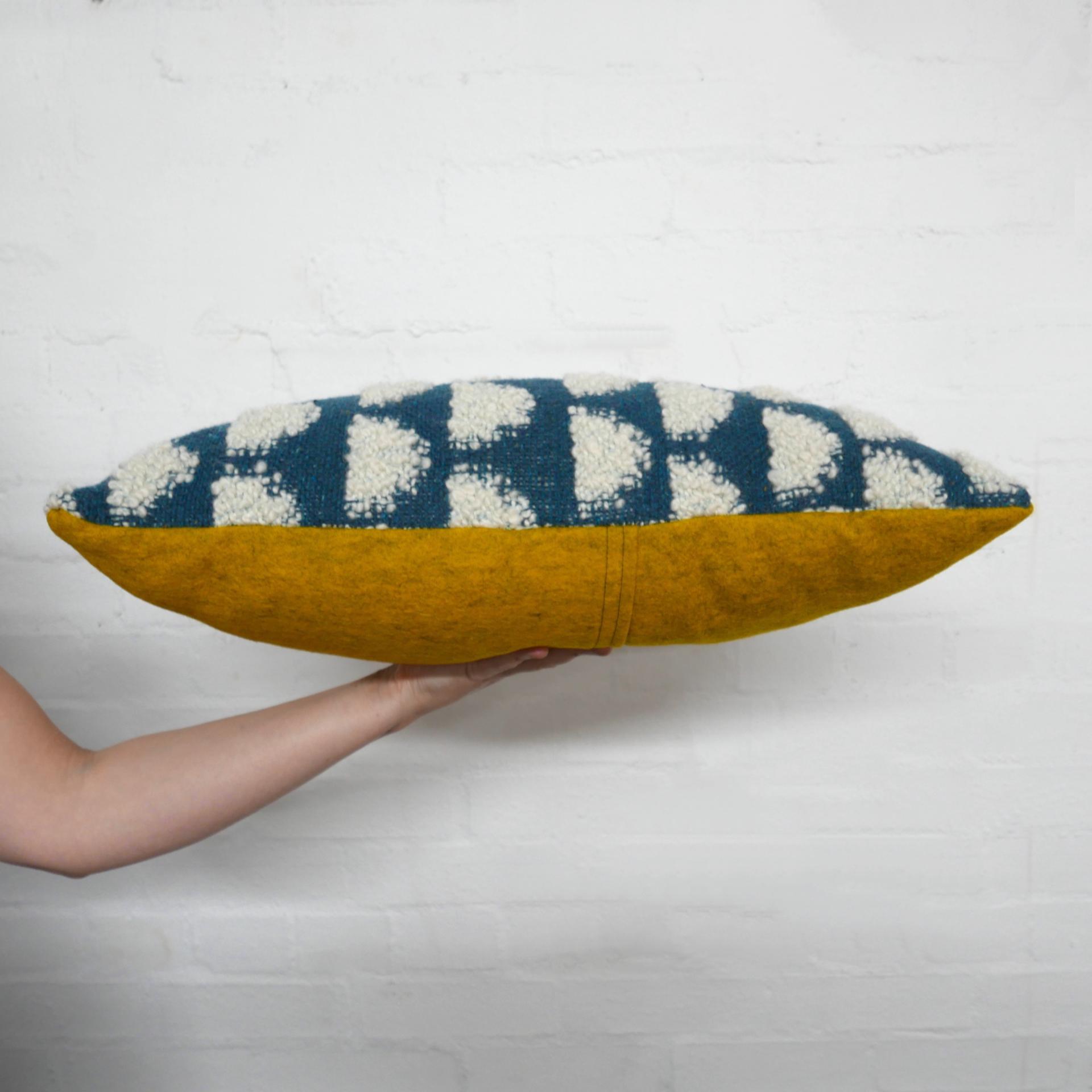 Handcrafted decorative pillow featuring a blue and cream patterned fabric with a bold yellow underside, showcasing Glasgow's creative craft.