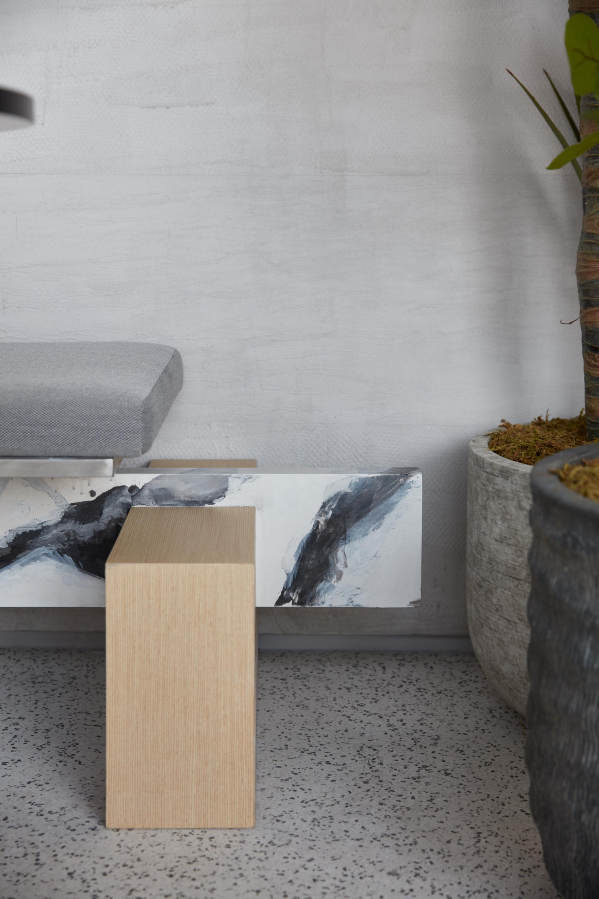 Minimalist coffee shop interior featuring textured seating and artistic wooden furniture accents in a serene atmosphere.
