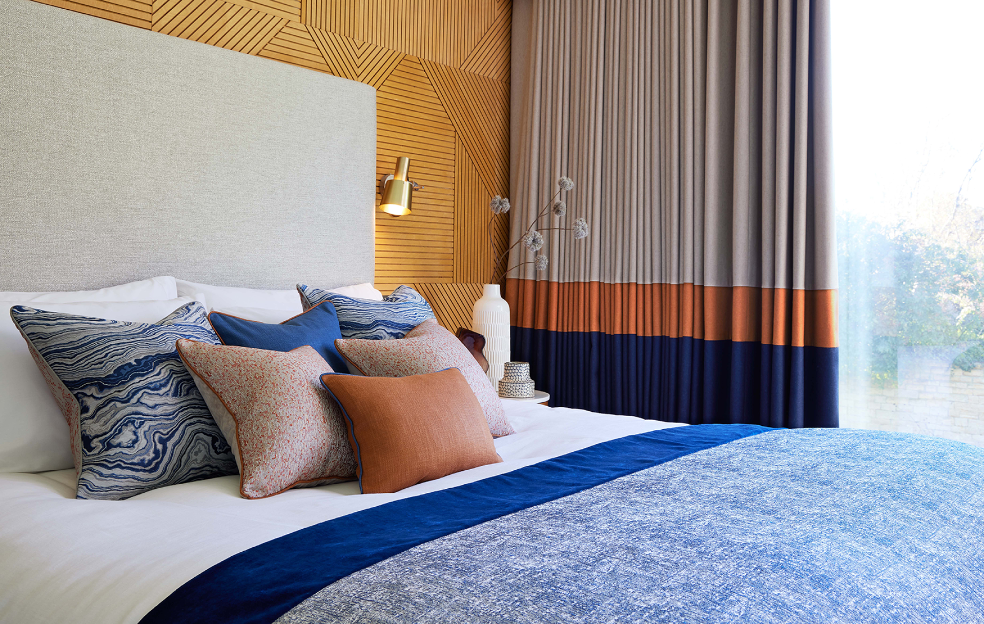 Stylish bedroom featuring textured fabrics and colorful cushions, highlighting contemporary design by Panaz.