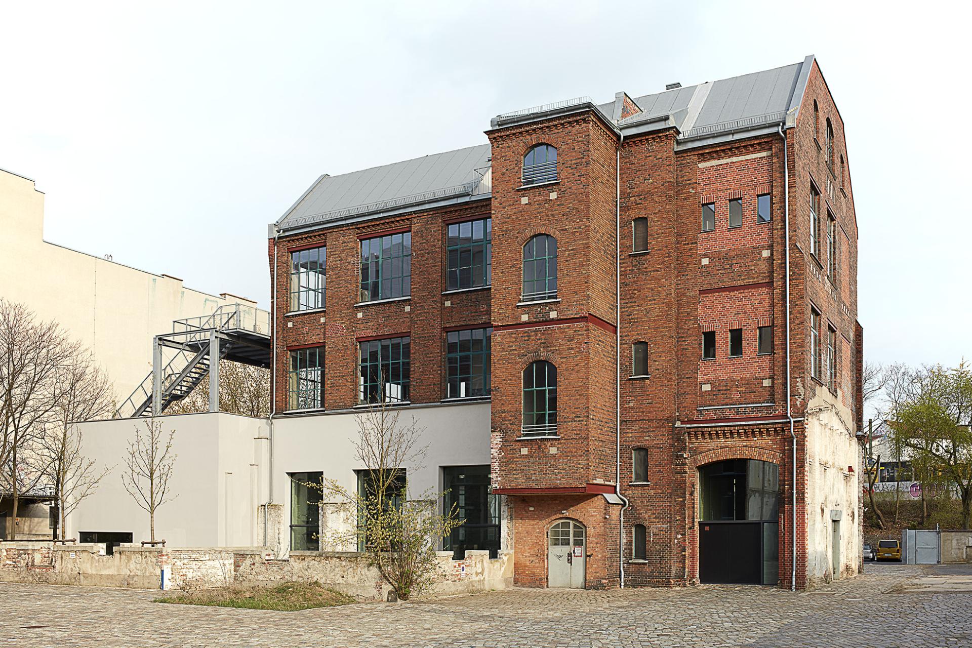 Redeveloped industrial building at Lindower 22, showcasing redbrick architecture and modern elements in an urban setting.