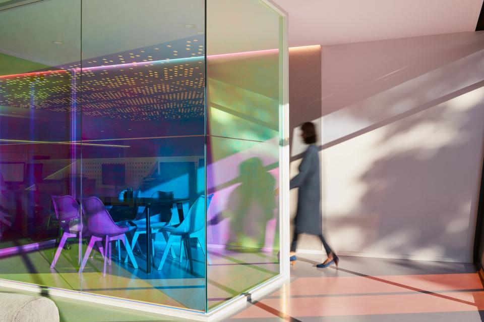 Brightly colored optical prism partitions enhance the vibrant workspace designed by Studio Y for Ambience's office environment.