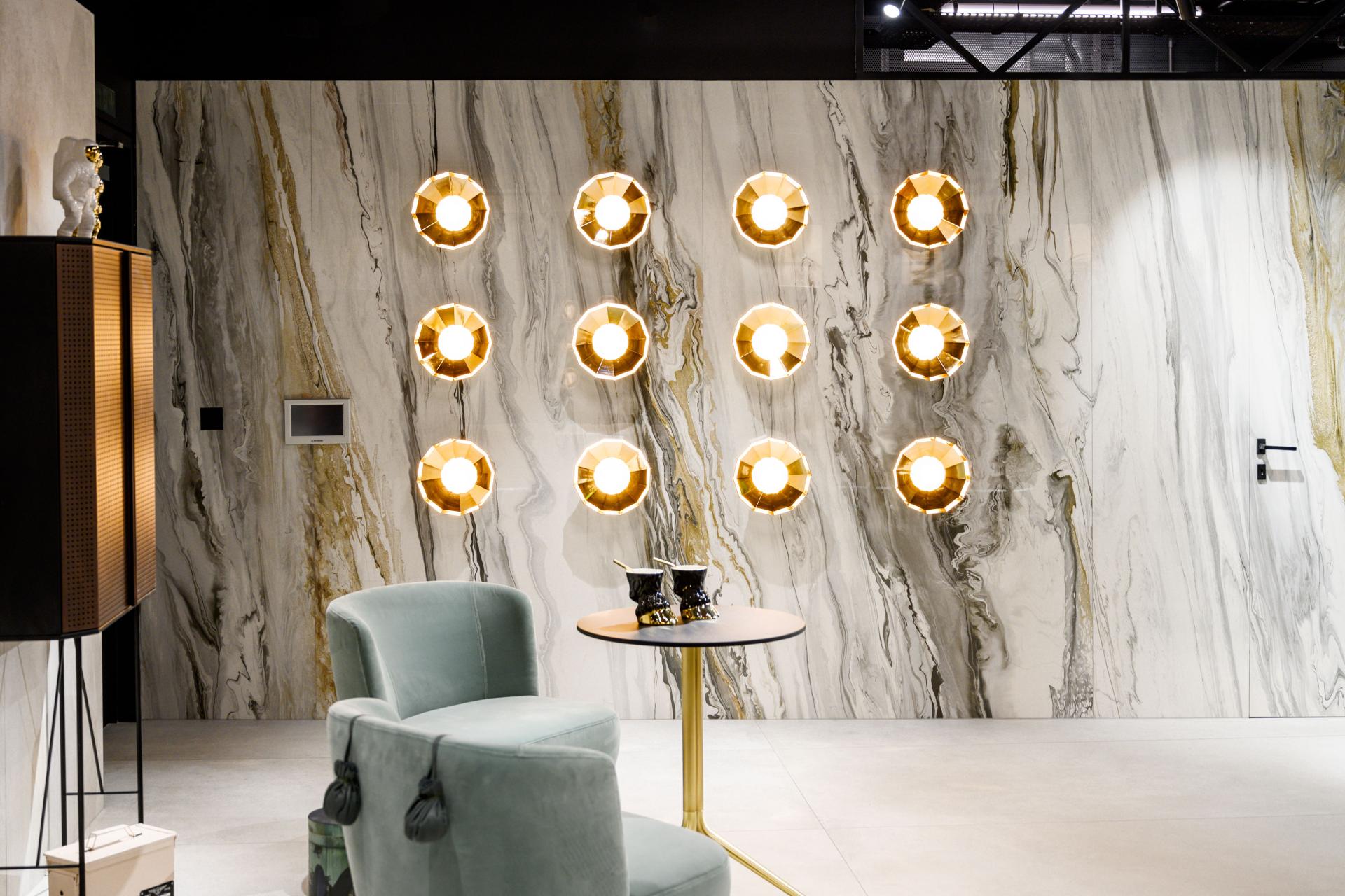 Contemporary showroom interior featuring elegant lighting design against a luxurious marble wall by Iris Ceramica Group.