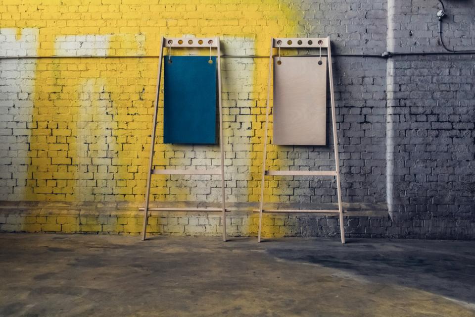 Flexible furniture display system against a colorful graffiti wall, featuring blue and natural wood panels for pop-up shops.