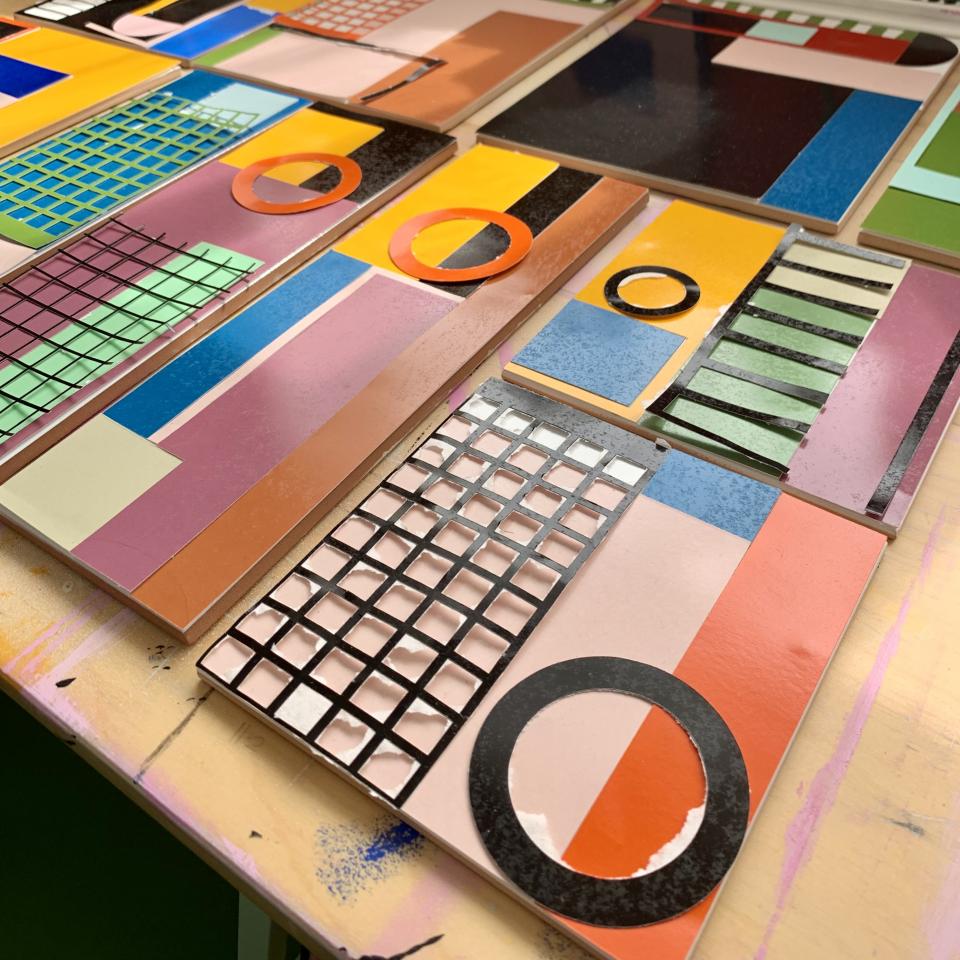 Colorful ceramic tiles showcasing geometric patterns and vibrant enamel glazes crafted by artist Laura Lightbody.